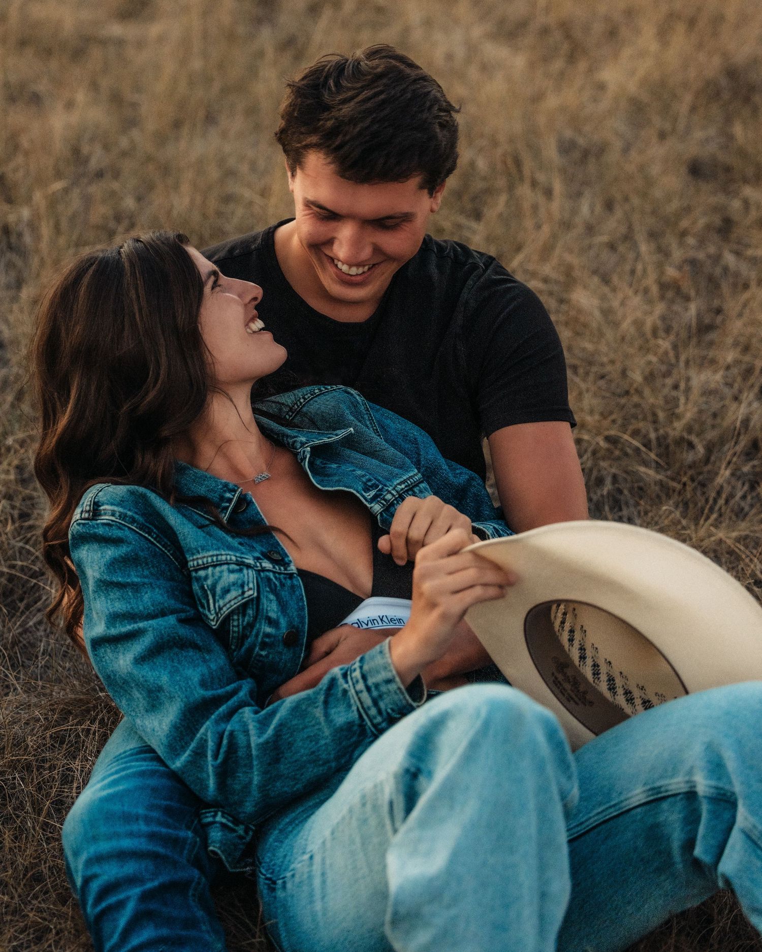Romantic country engagement photos with couple in denim sharing intimate moments.