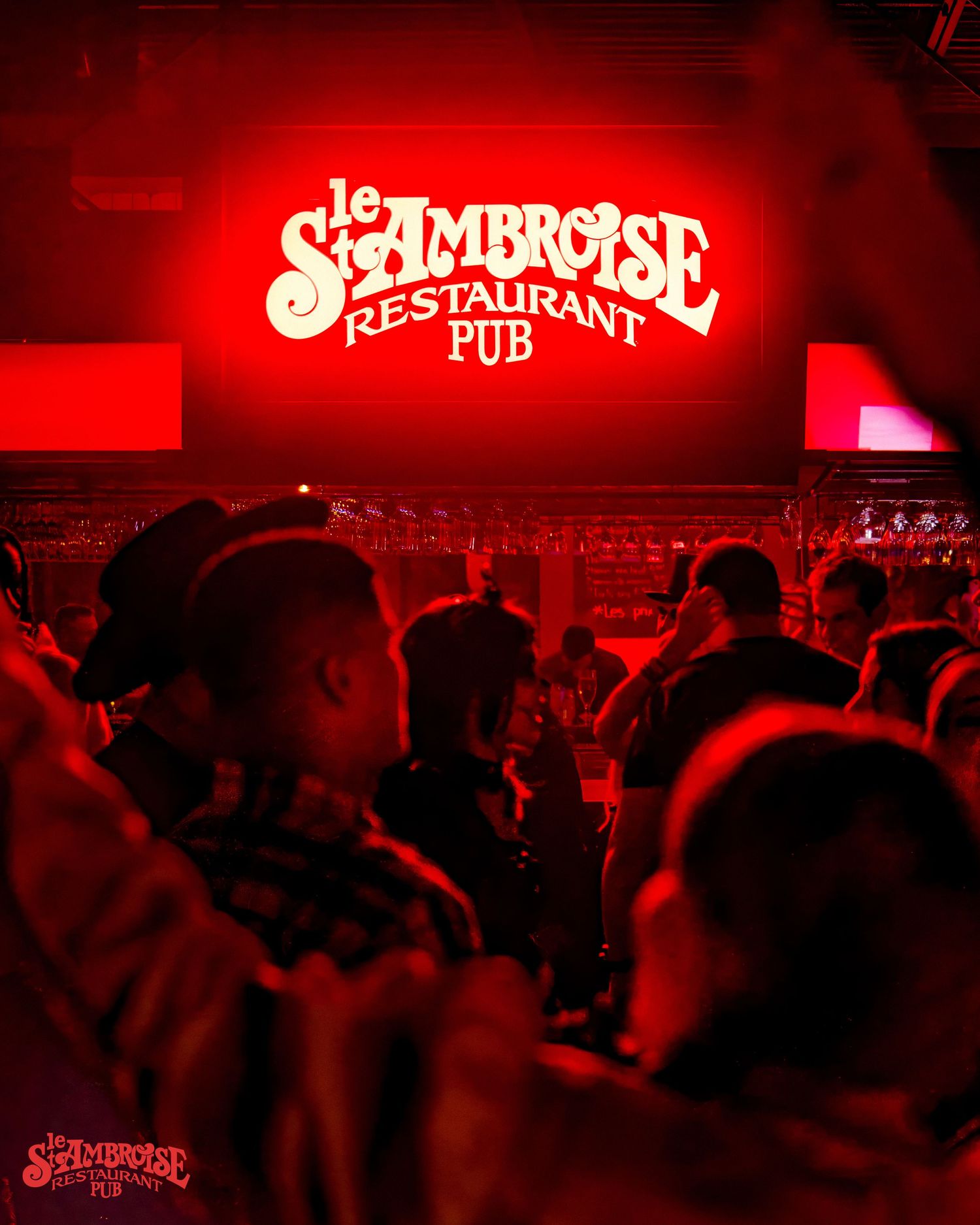 Crowded nightclub scene with red lighting and St-Ambroise pub signage.
