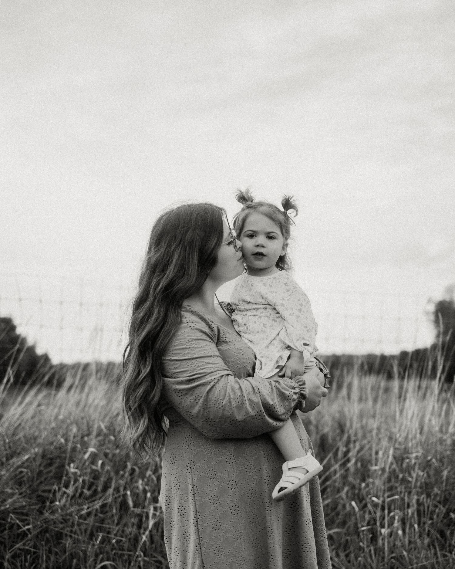 Black and white portraits captured in a natural field setting.