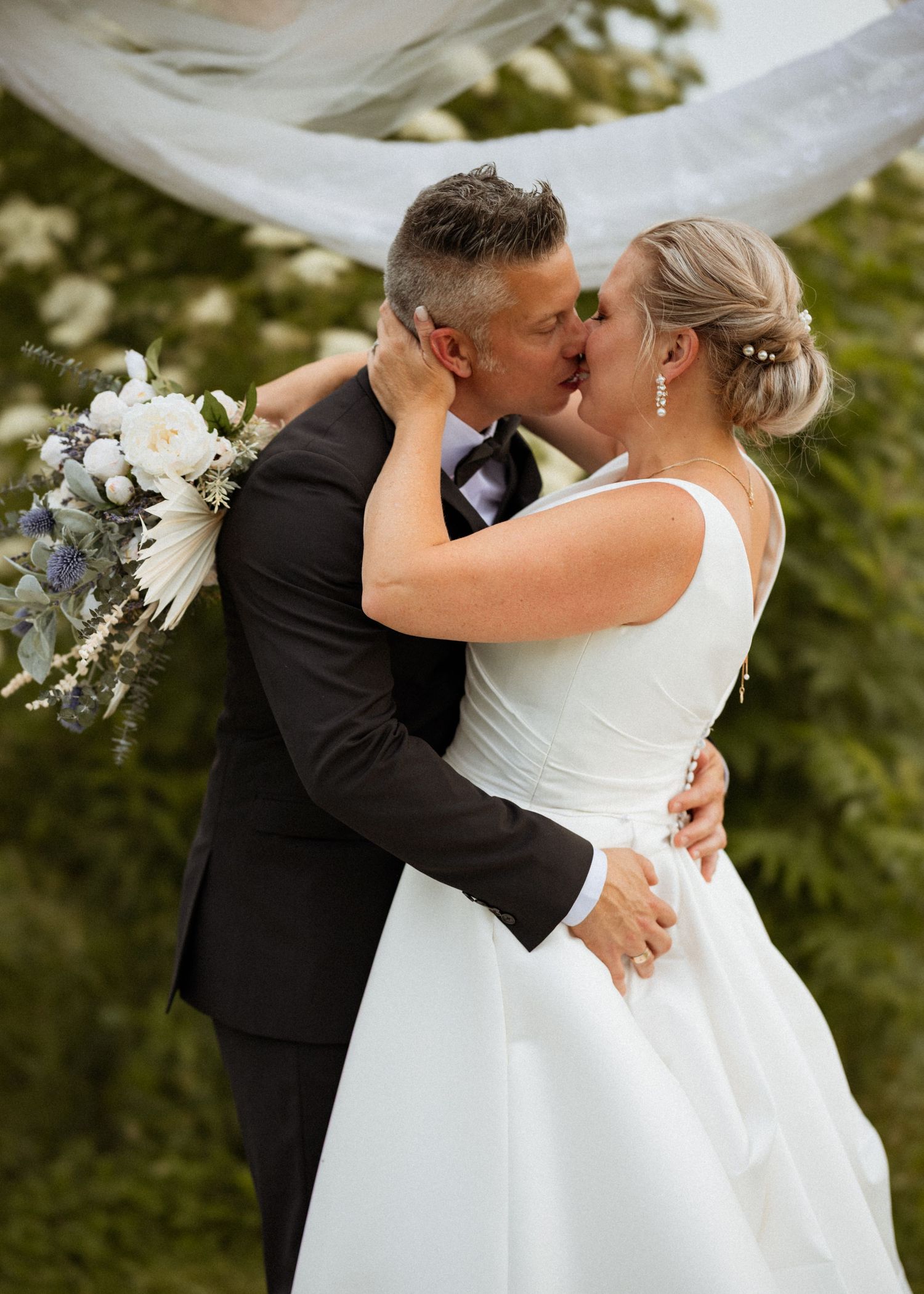 Romantic outdoor wedding photos showing intimate moments between newlyweds.