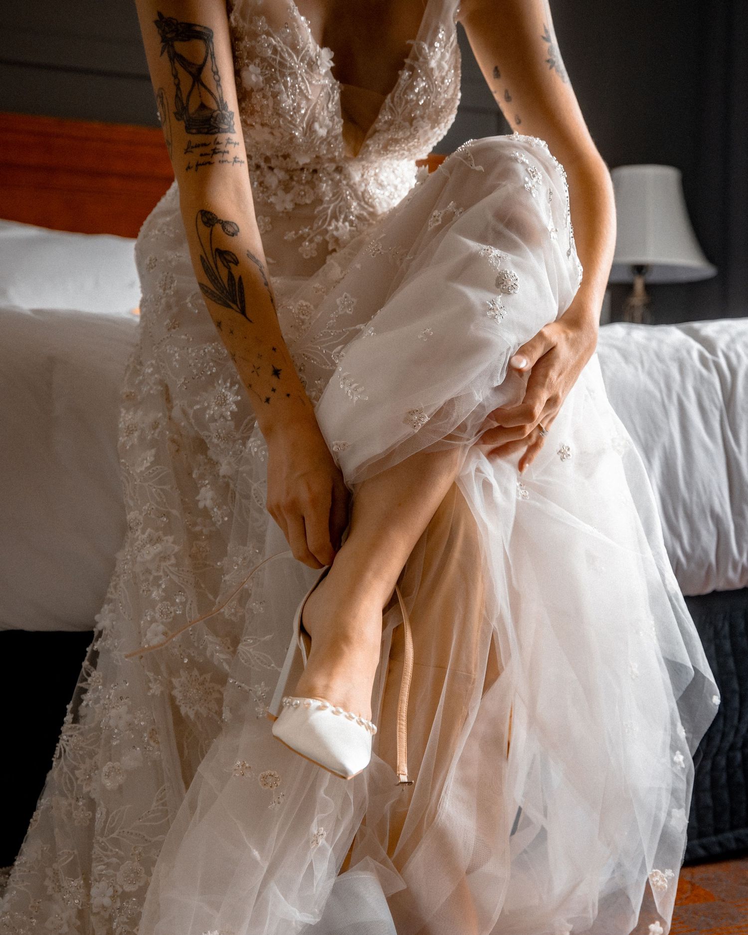Close-up details of a white lace wedding dress with intricate embroidery patterns.