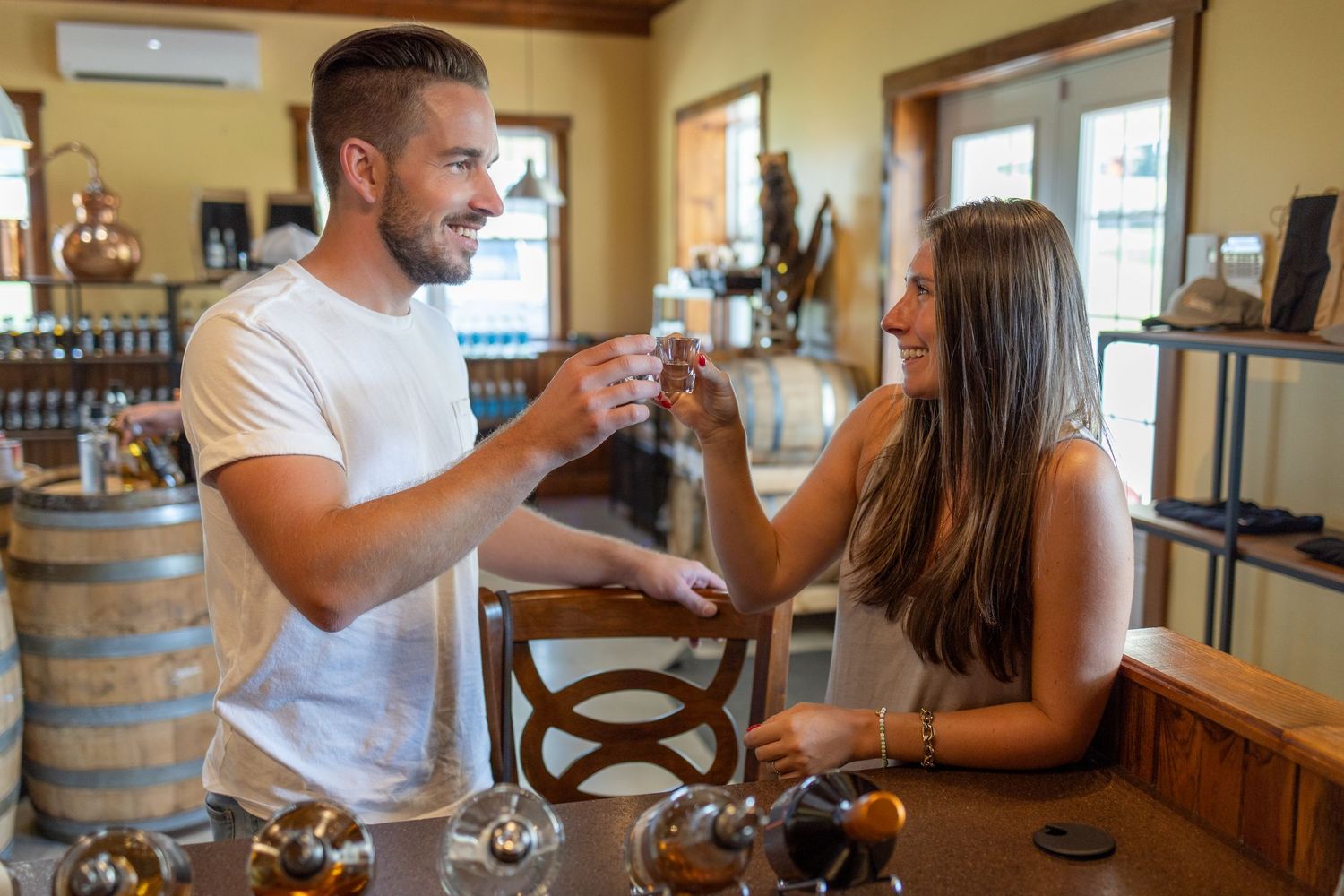 Tasting room experience with guests sampling beverages at a wooden bar.
