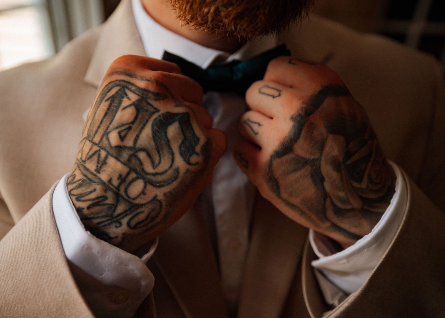 Close-up of tattooed arms against warm brown background.