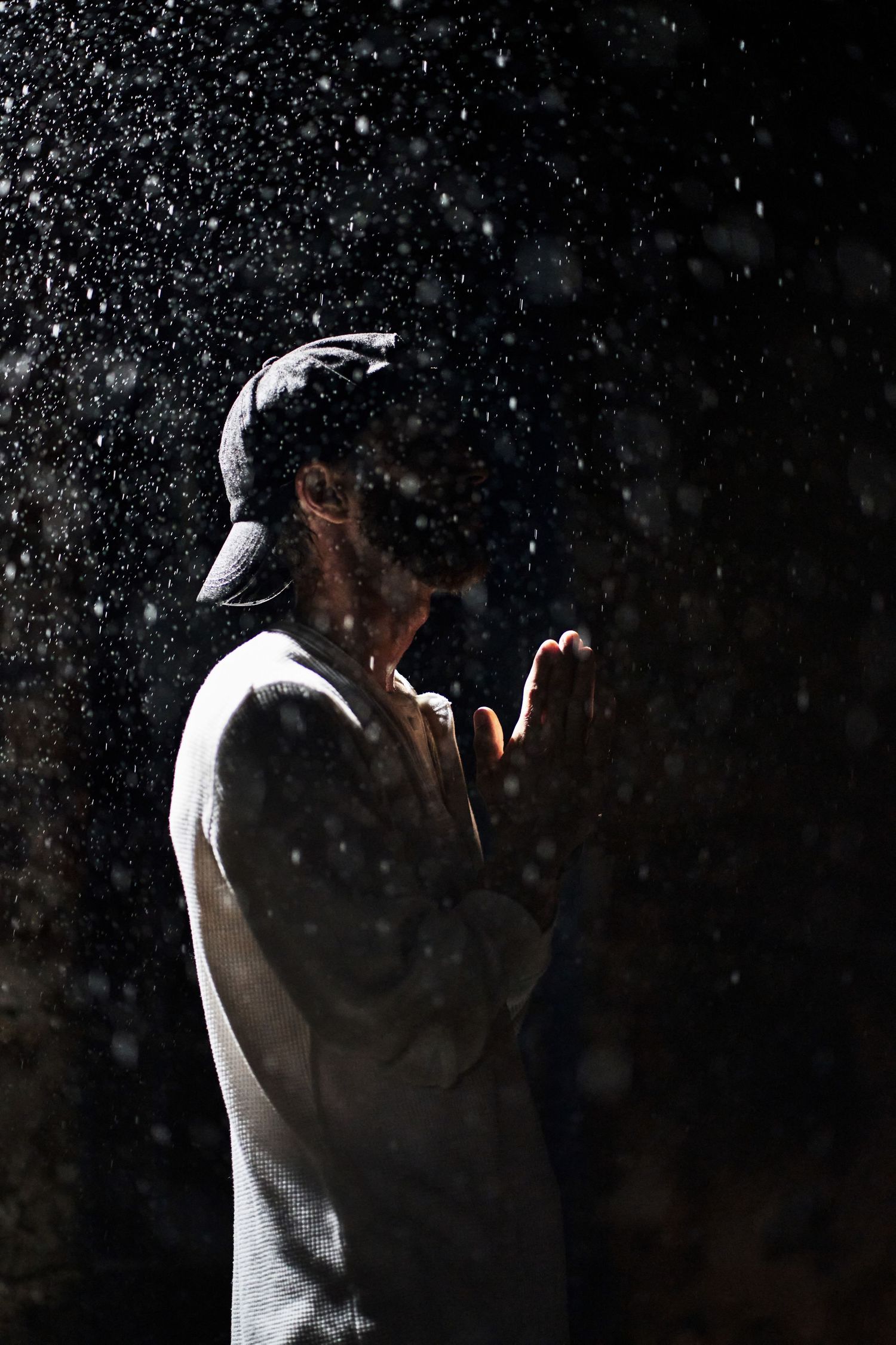 Dramatic black and white portrait sequence showing a silhouetted figure in motion against a dark background.