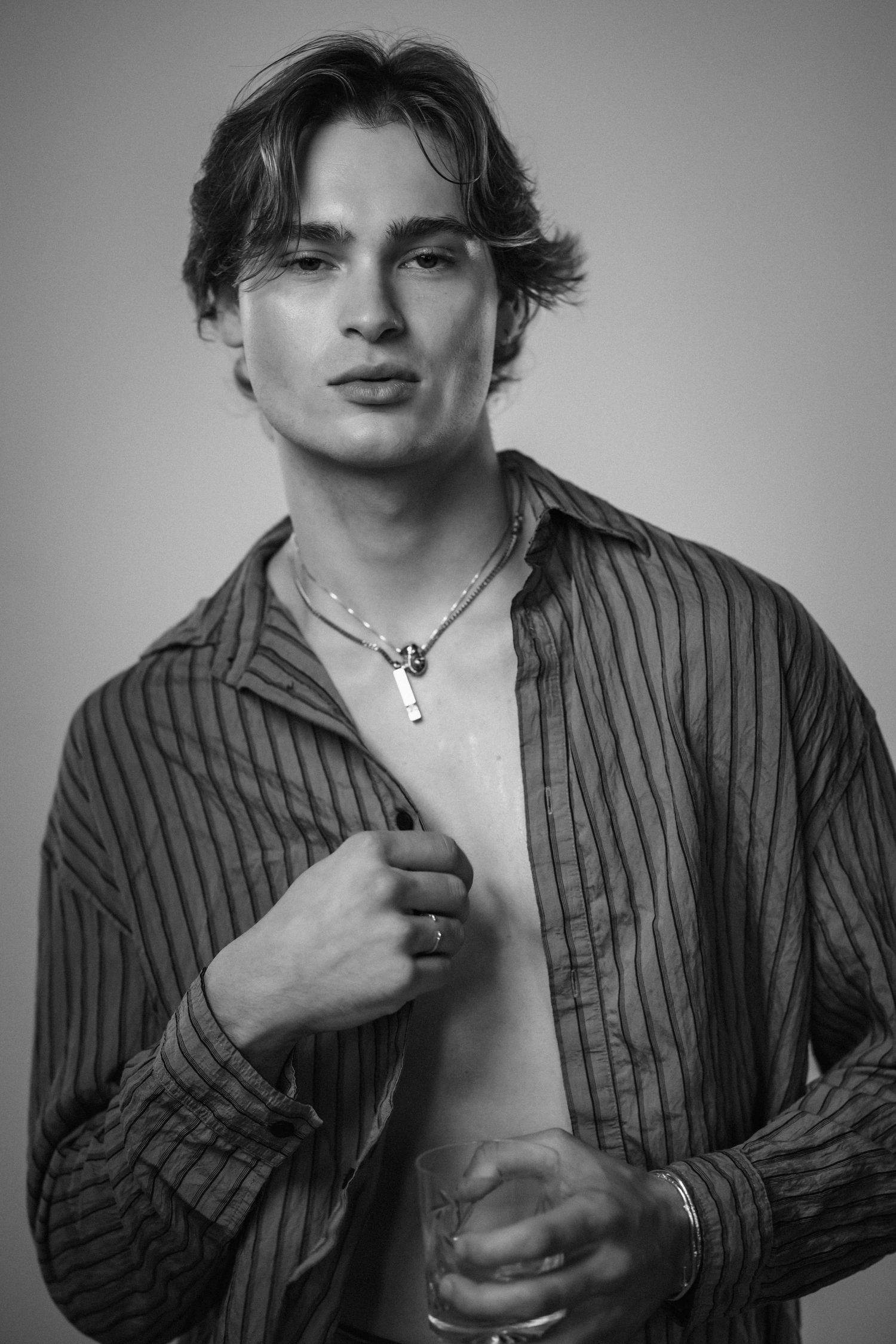Dramatic black and white portrait series showing expressions in striped shirt.