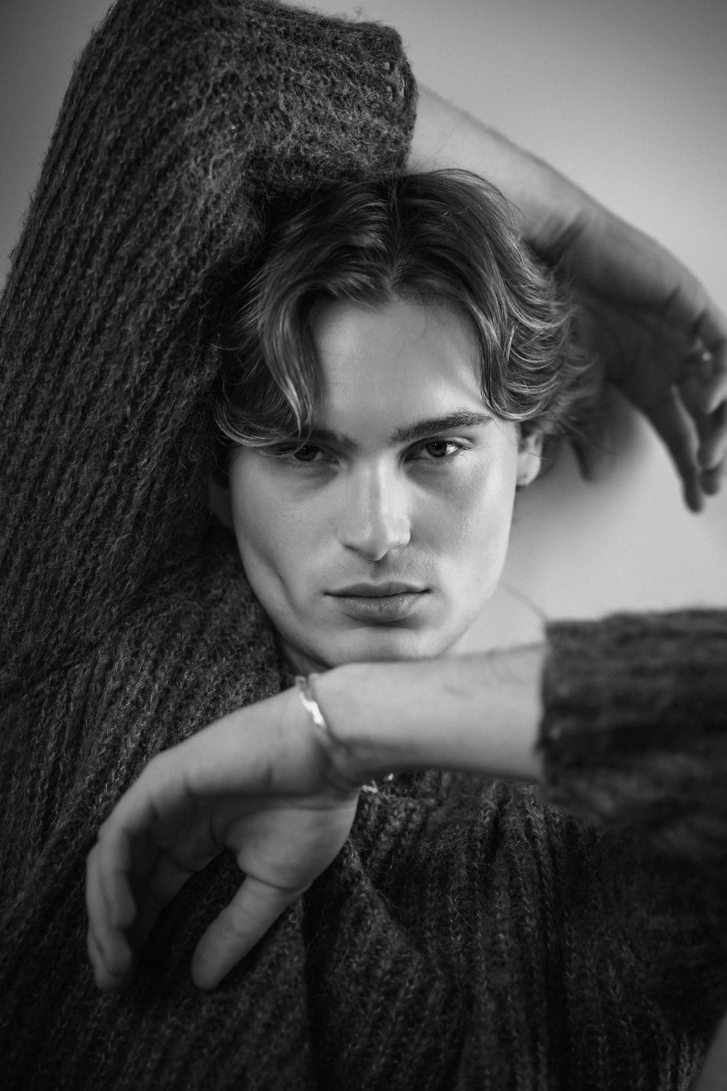 Moody black and white portraits with dramatic hand gestures and sweater.