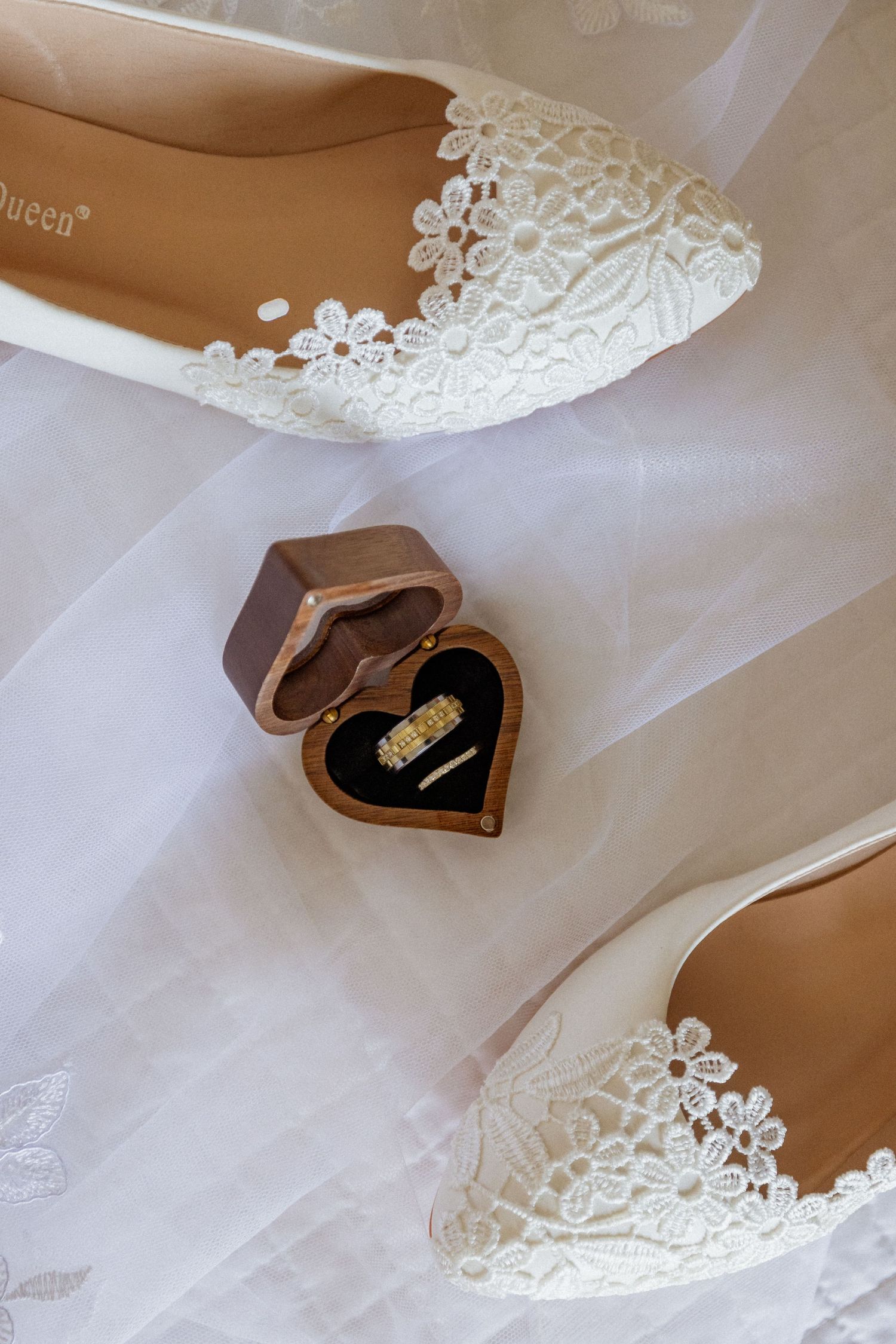 Delicate white lace veil with floral patterns draped over a heart-shaped box.