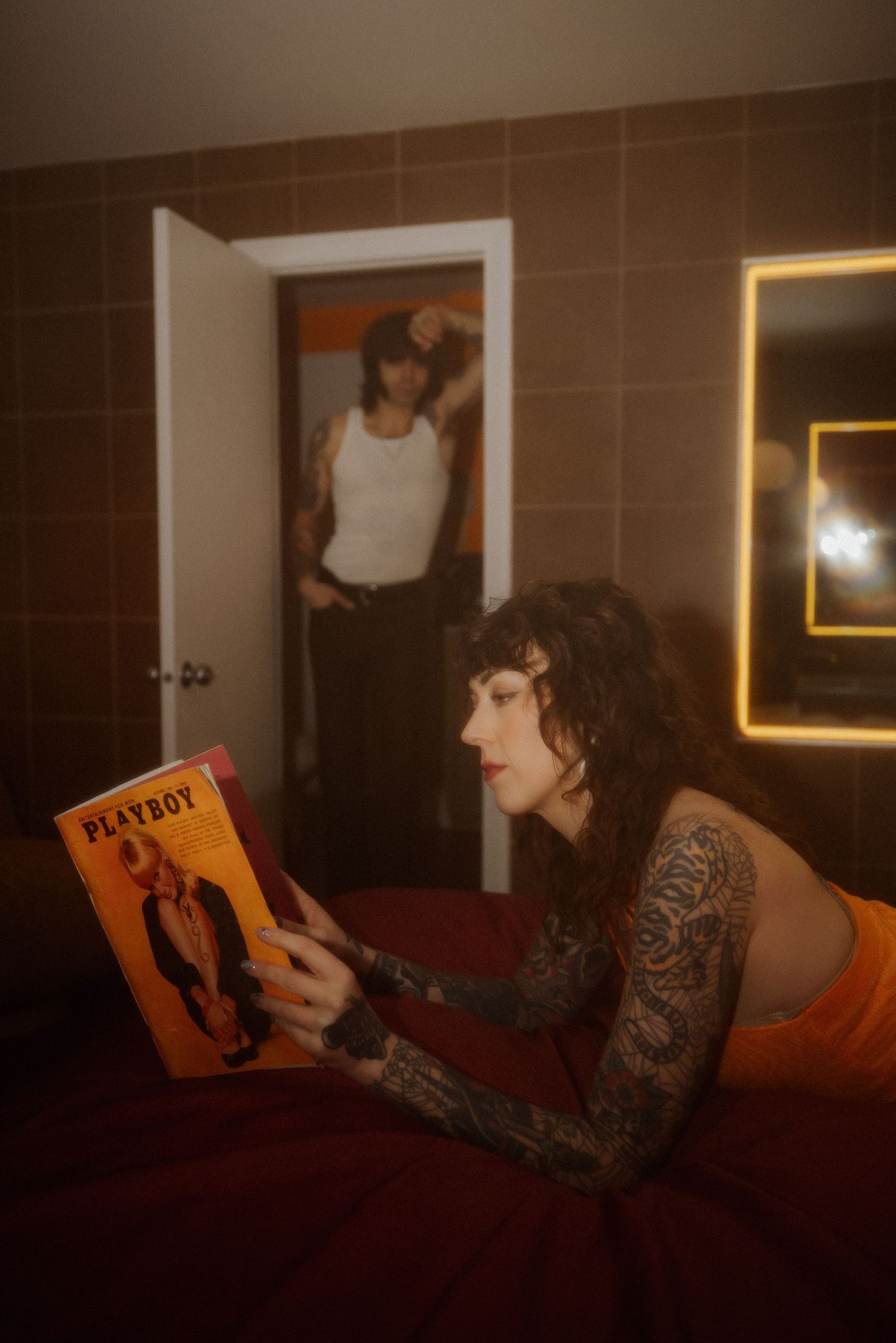 Person relaxing and reading a magazine in dimly lit room with vintage decor.