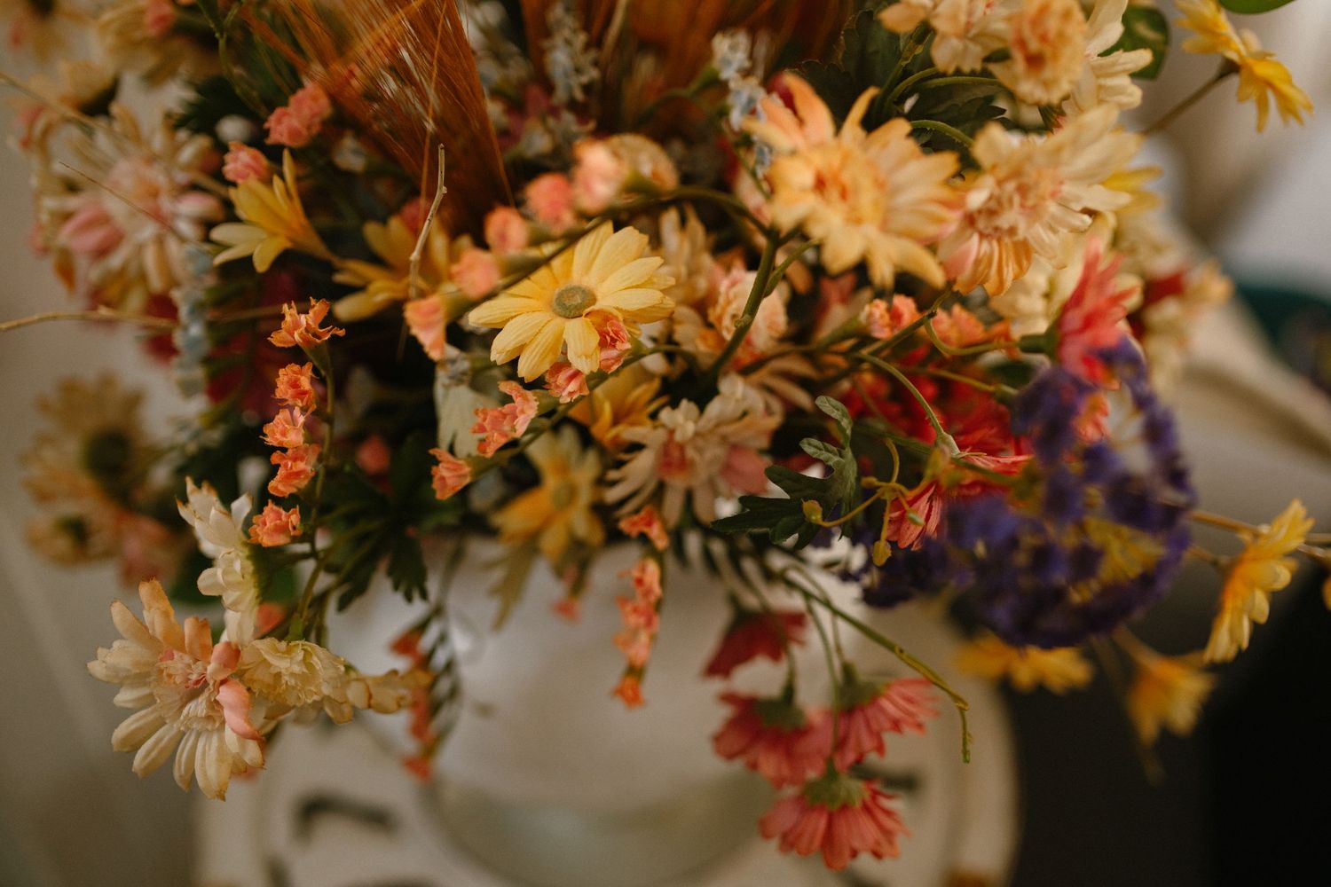 Romantic autumn-toned floral arrangement with mixed wildflowers and dried blooms.