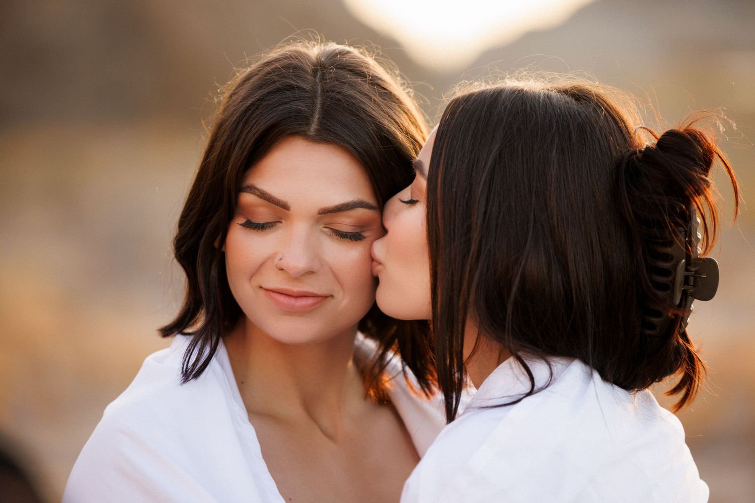 Intimate portrait of couple sharing affectionate moment in warm sunlight.