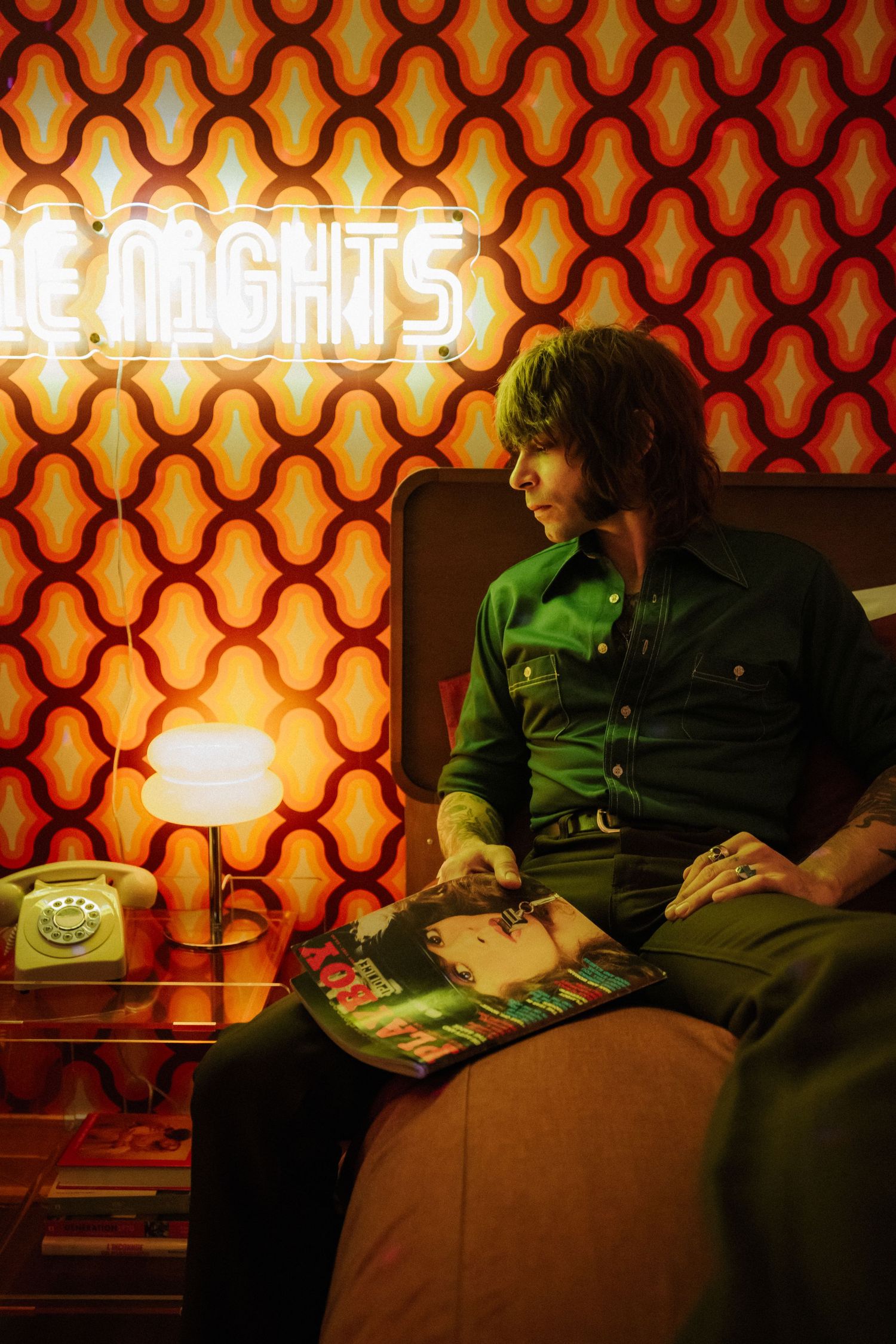 Interior scene with retro wallpaper and vintage lamp casting warm orange glow.