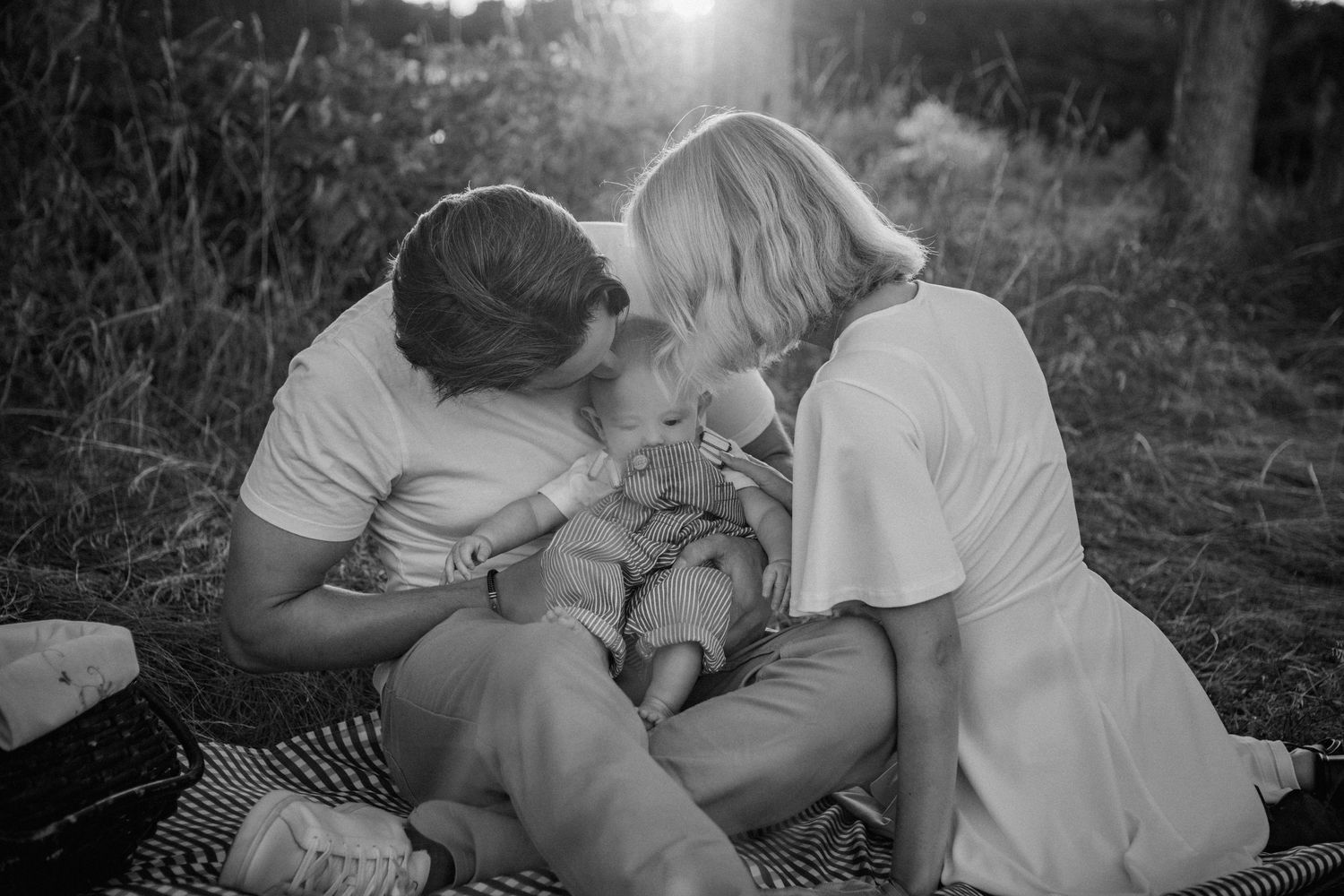Intimate family moment captured in black and white photography outdoors.