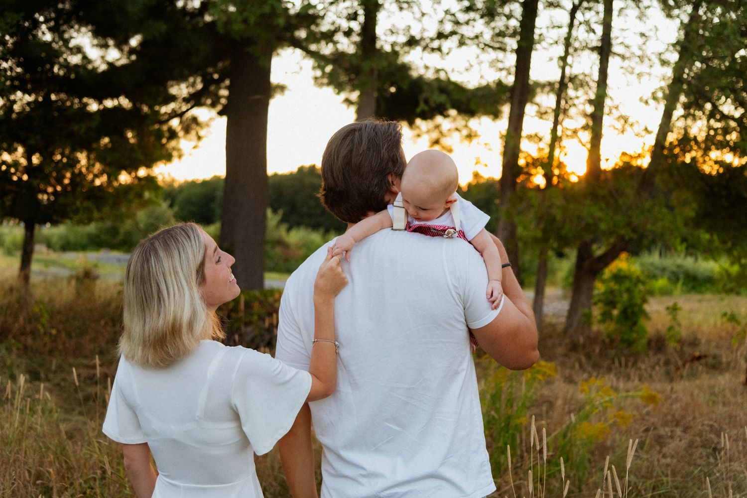 Family walking together at sunset in a wooded area.