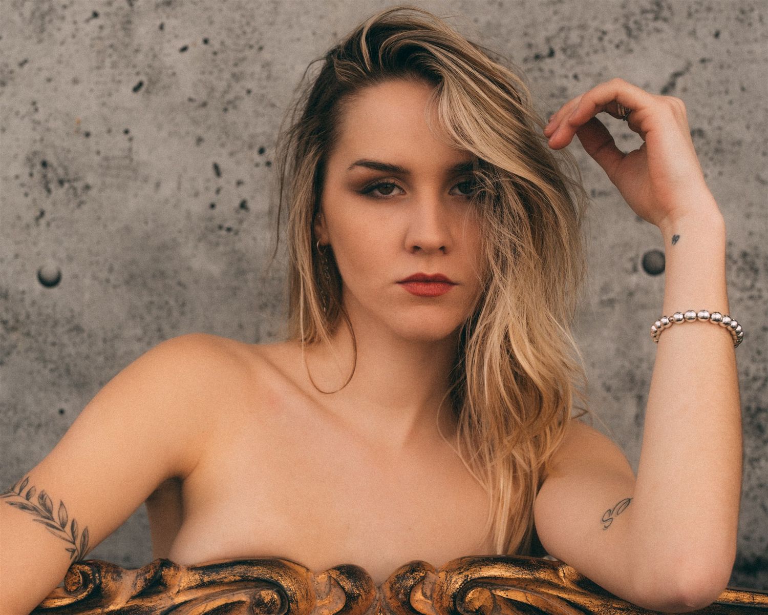 Artistic portrait series against textured concrete wall with dramatic lighting.