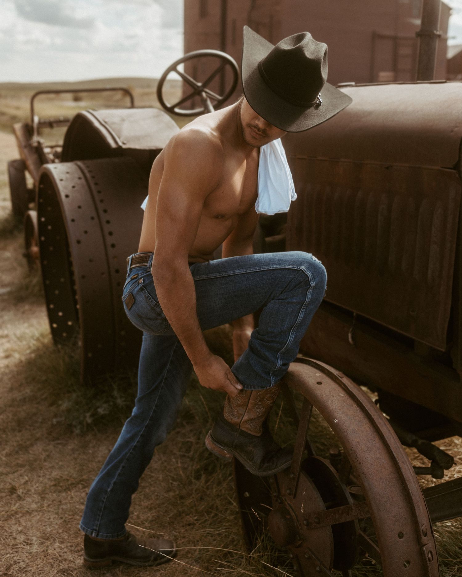 Close-up of denim-clad person working on vintage train equipment.