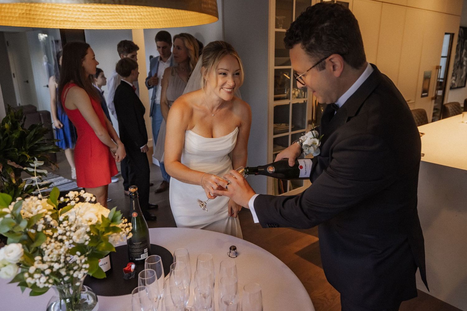 Newlyweds celebrating with champagne and cake cutting at an indoor reception.