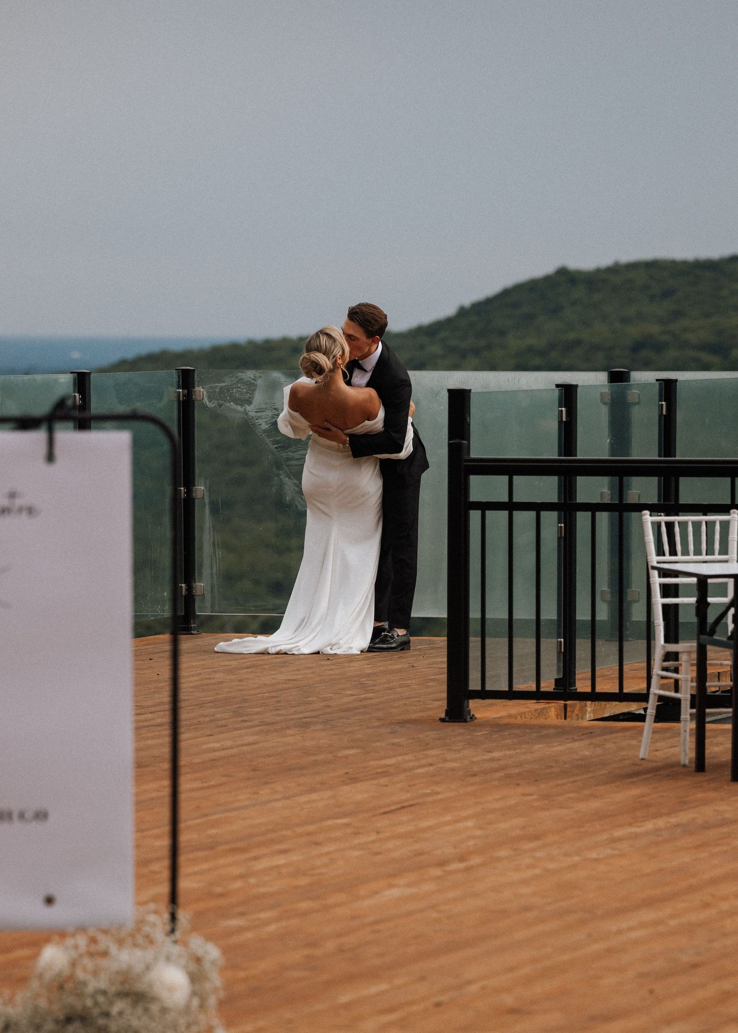 Romantic wedding moment captured on scenic mountain deck at sunset.