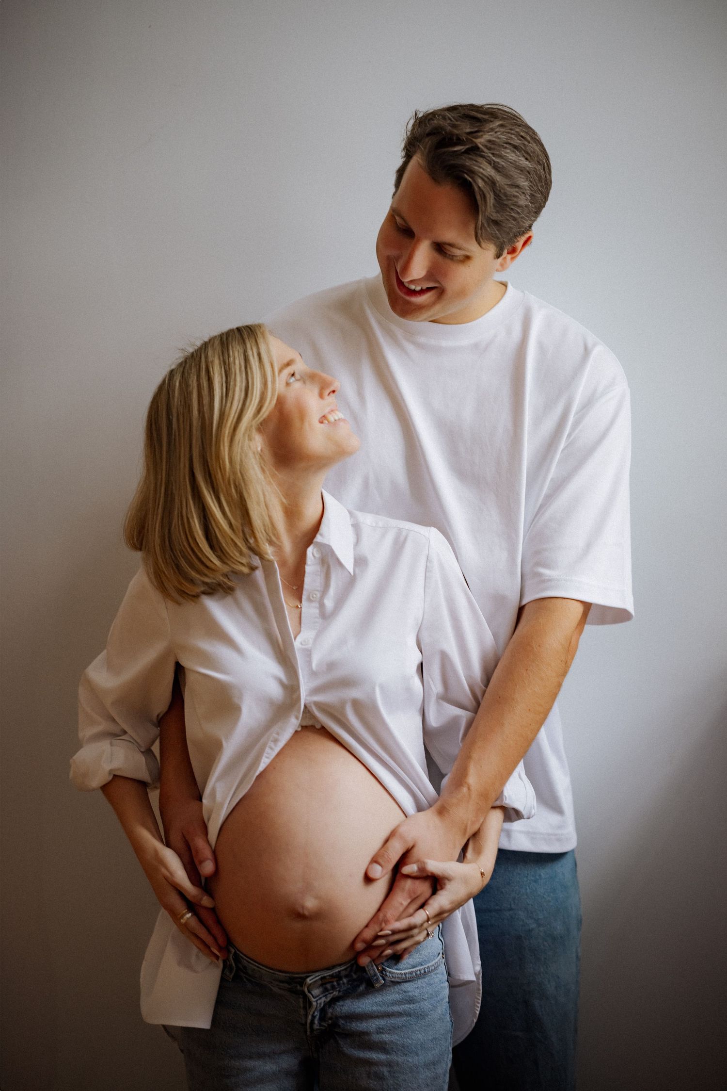 A series of candid maternity photos showing joyful moments between a couple.