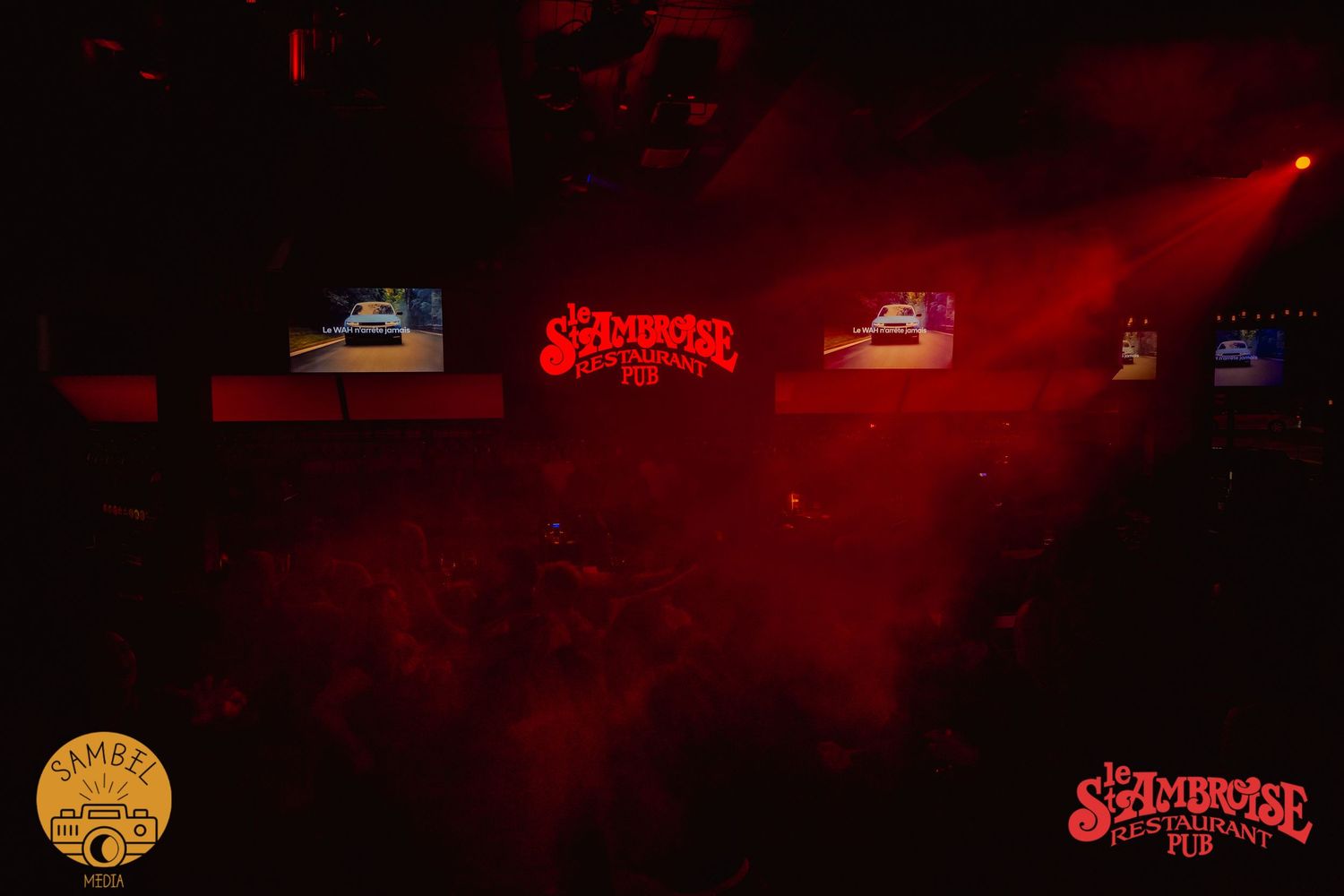 Dark nightclub interior with red lighting effects and hazy atmosphere.