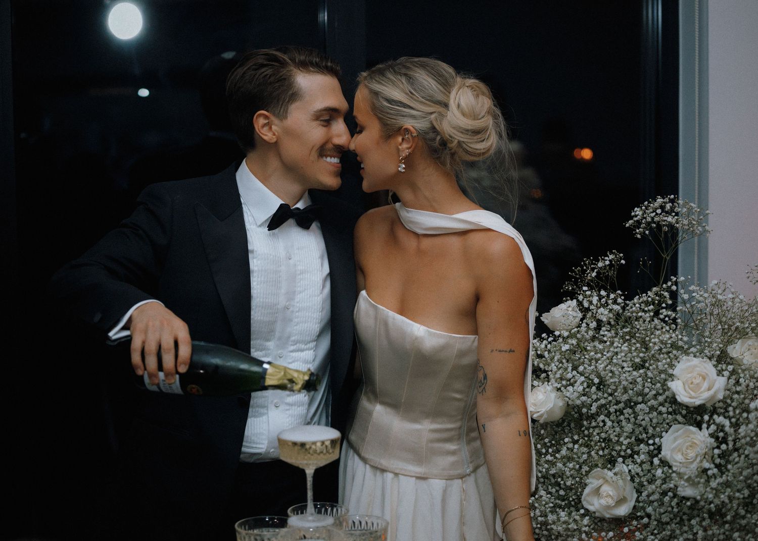Intimate wedding reception moment under moonlight with champagne.