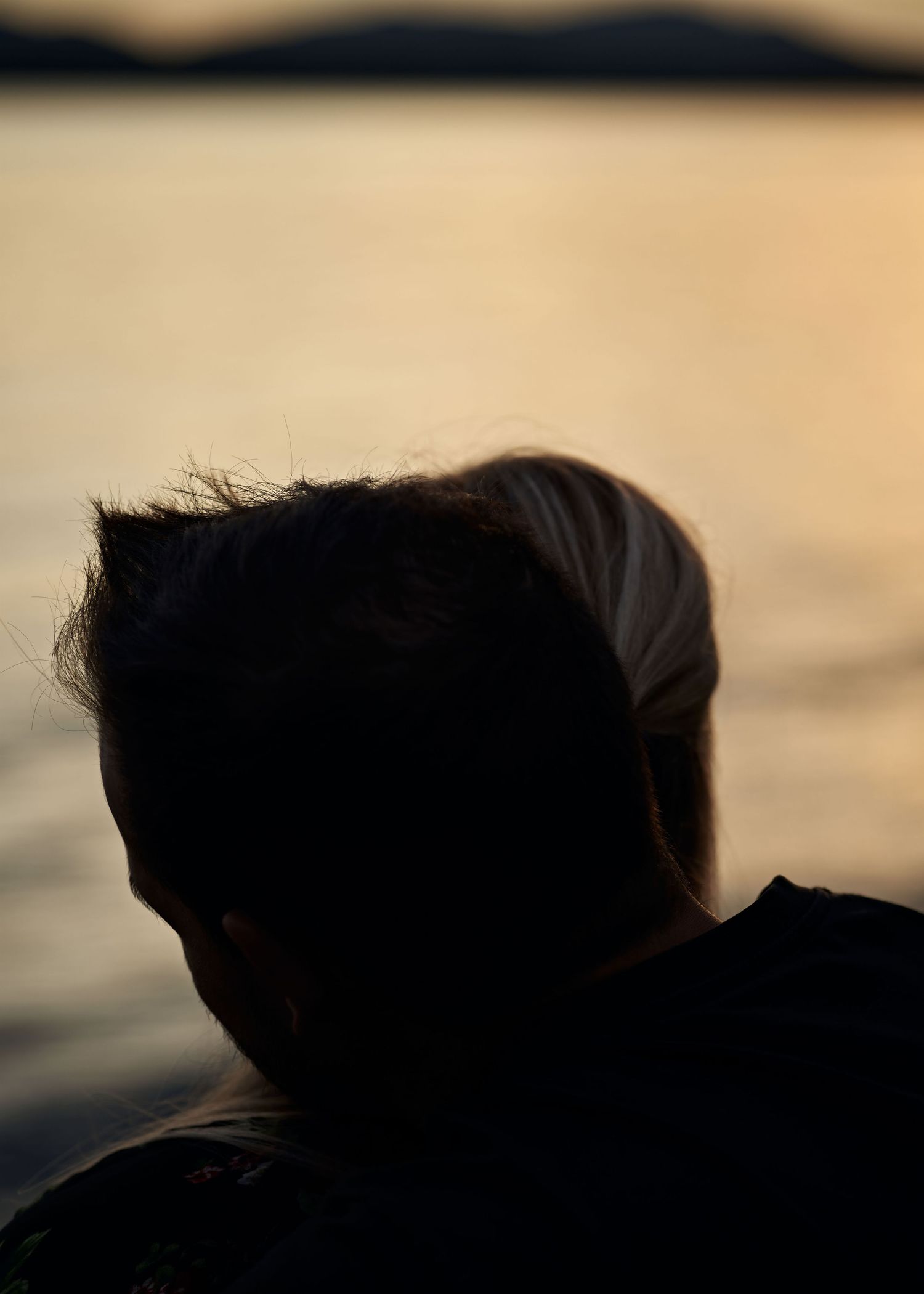 Silhouettes of figures against a warm sunset sky.