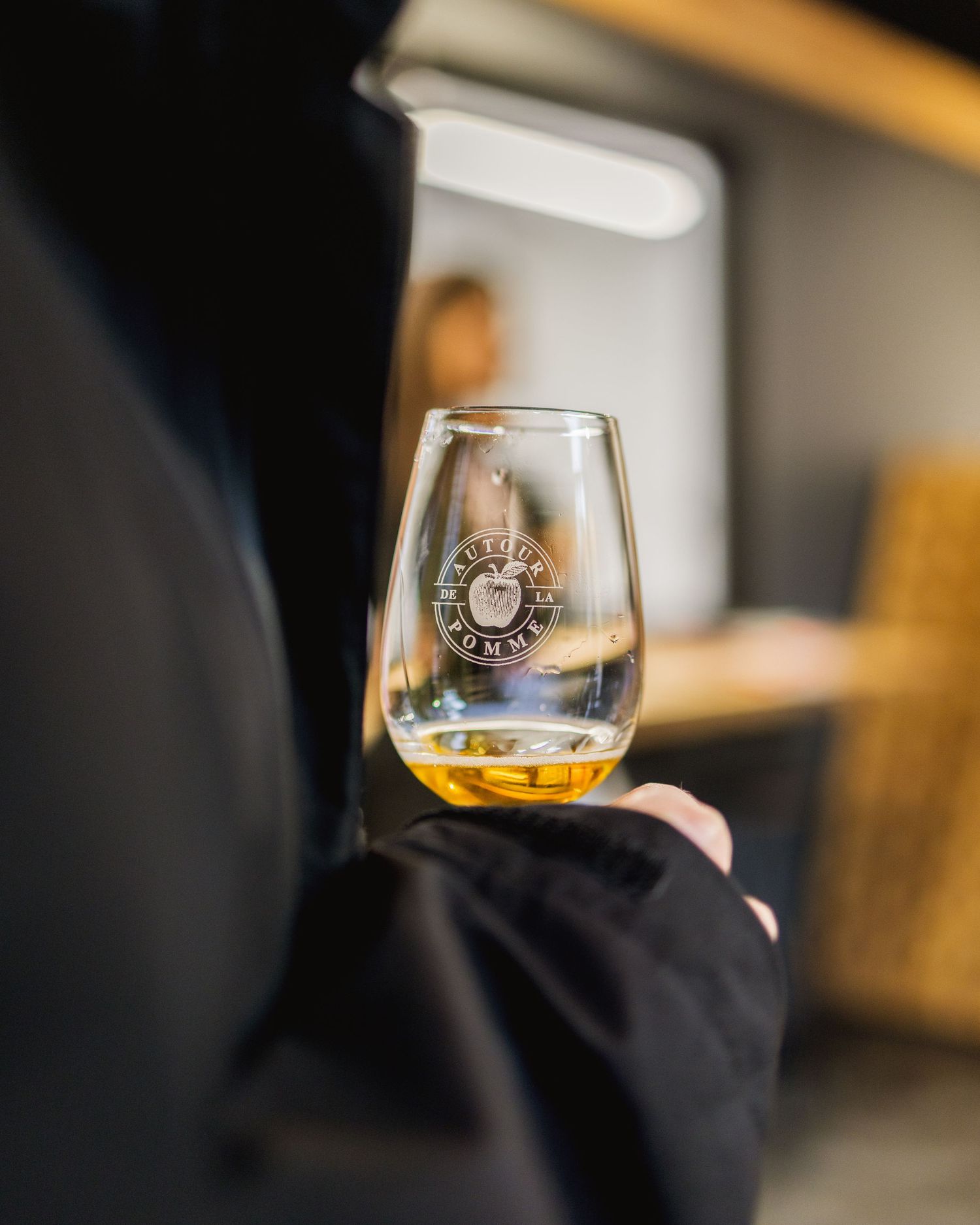 Close-up of wine glasses being held during a tasting event with blurred background.