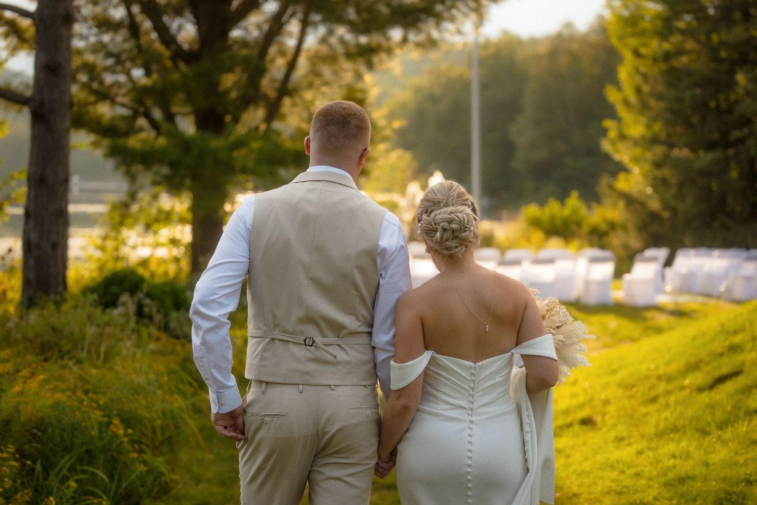 Newlyweds walking together during golden hour in natural outdoor setting.