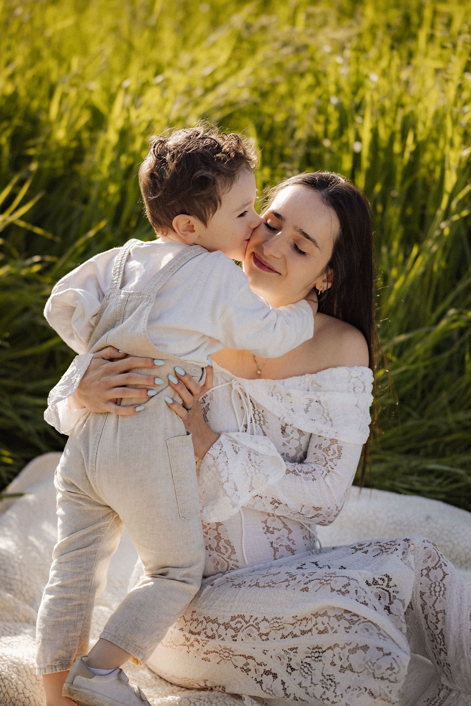 A tender family moment captured in a golden field during sunset.