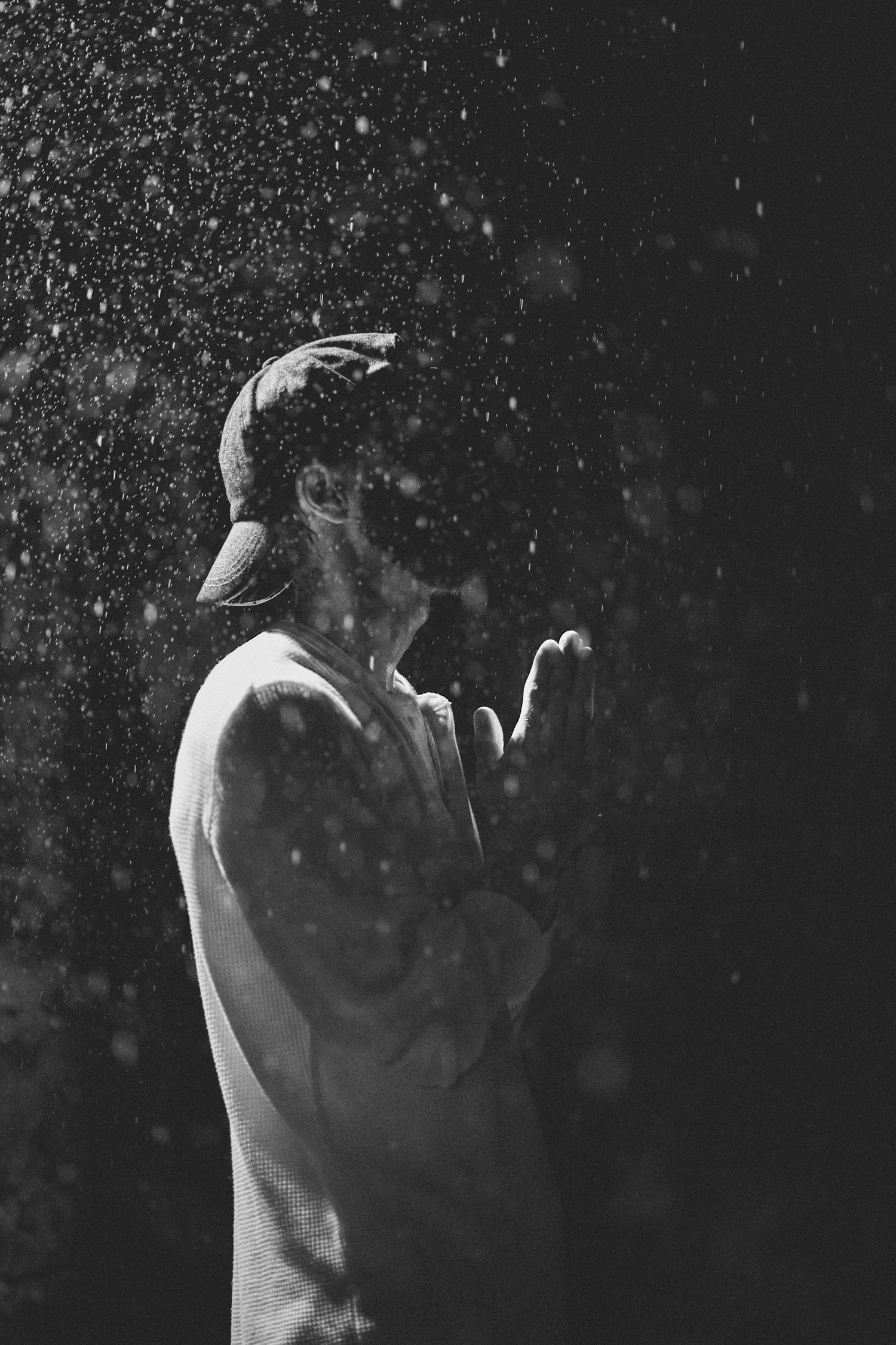 Artistic black and white portrait with water droplets creating a dramatic effect.