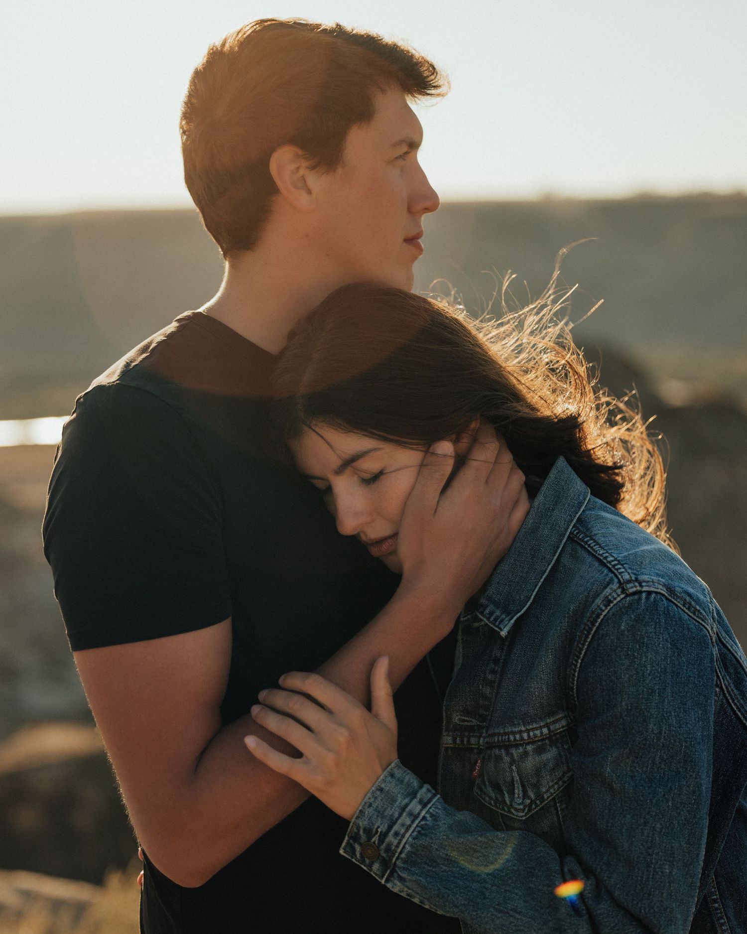 Tender embrace captured in warm sunset light against desert backdrop.