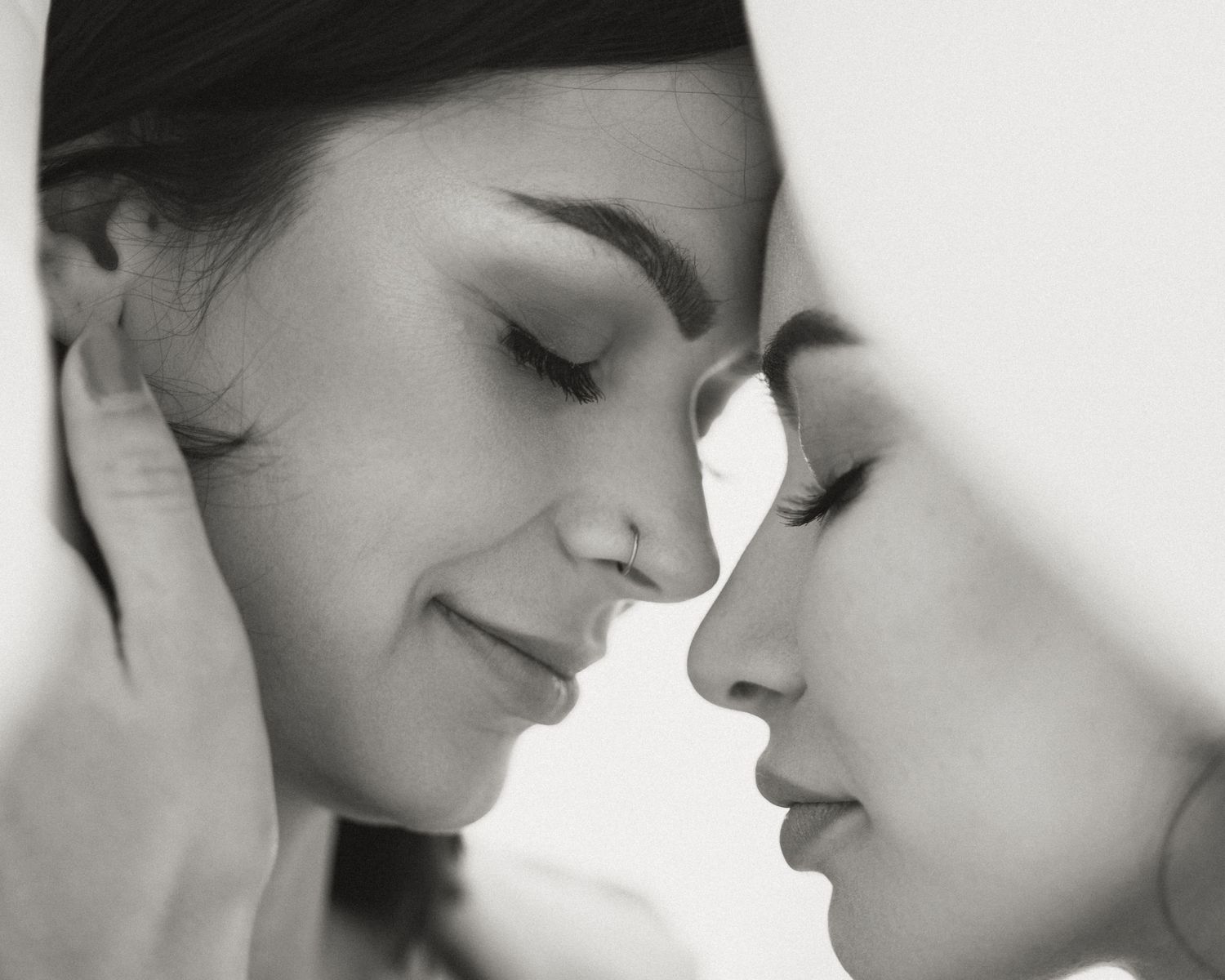 Black and white close-up portrait of two people in tender moment.