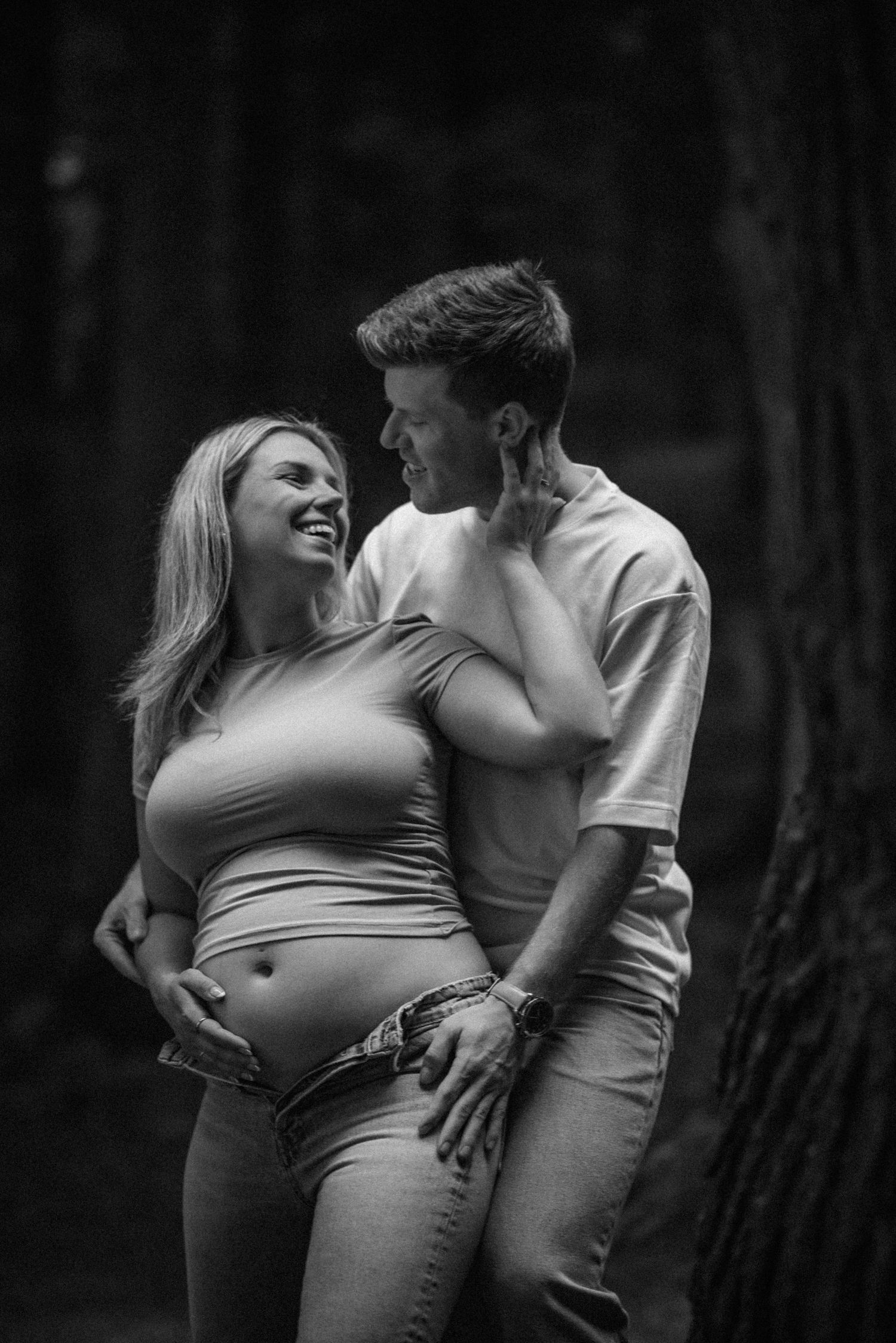Black and white maternity photo series showing tender moments between expecting couple.