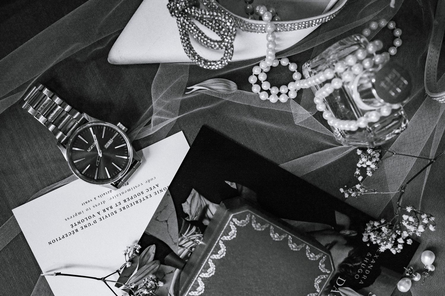 Elegant wedding accessories and jewelry arranged artistically in black and white.