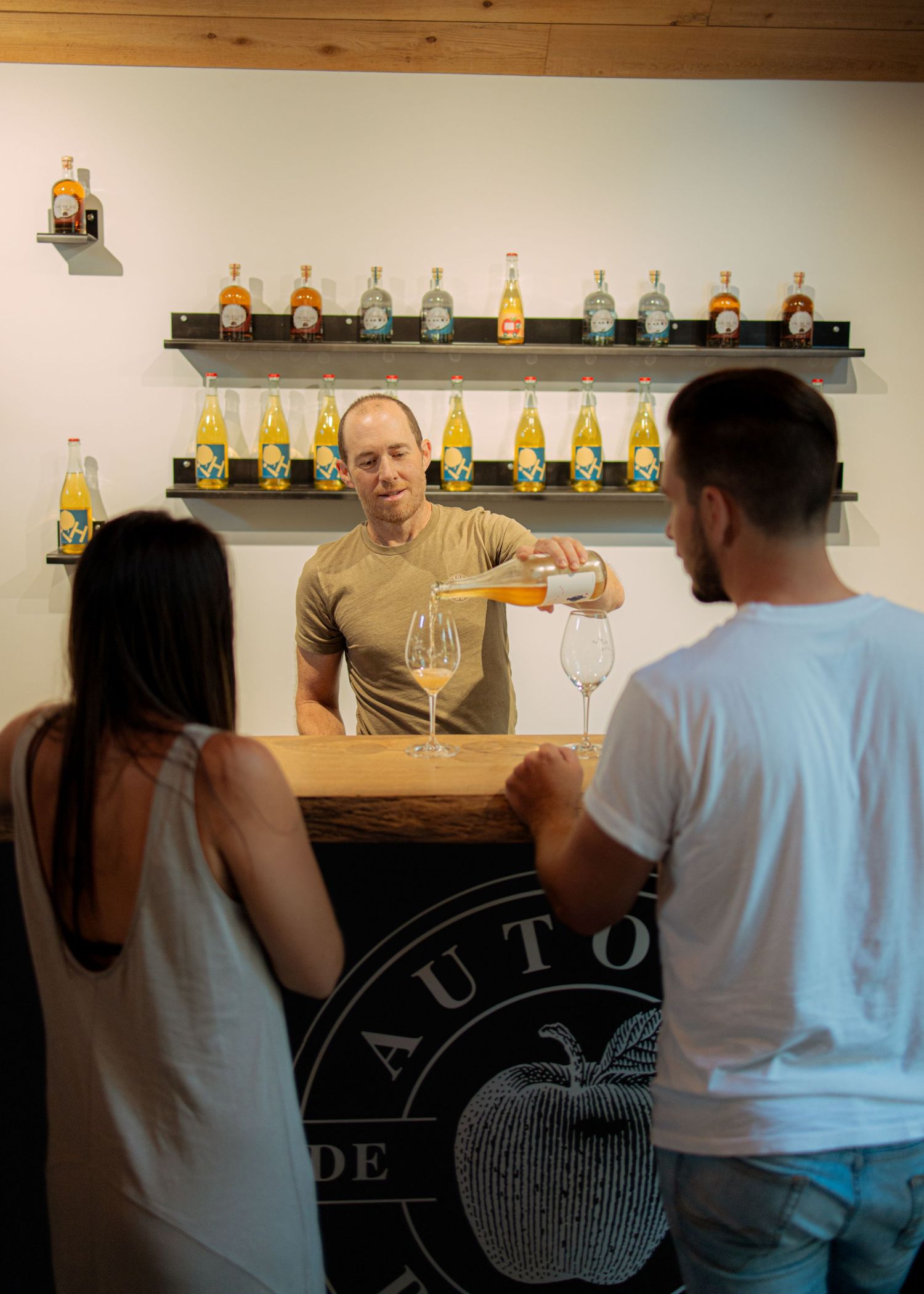 Interior view of a tasting room with decorative bottles displayed on wall shelves.
