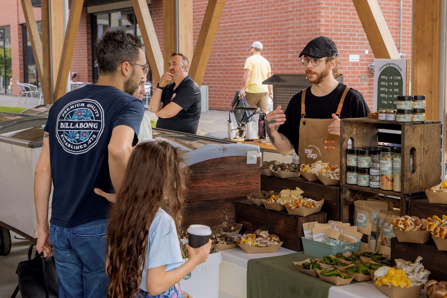 Vendors and customers interact at indoor market stalls with fresh produce displays.