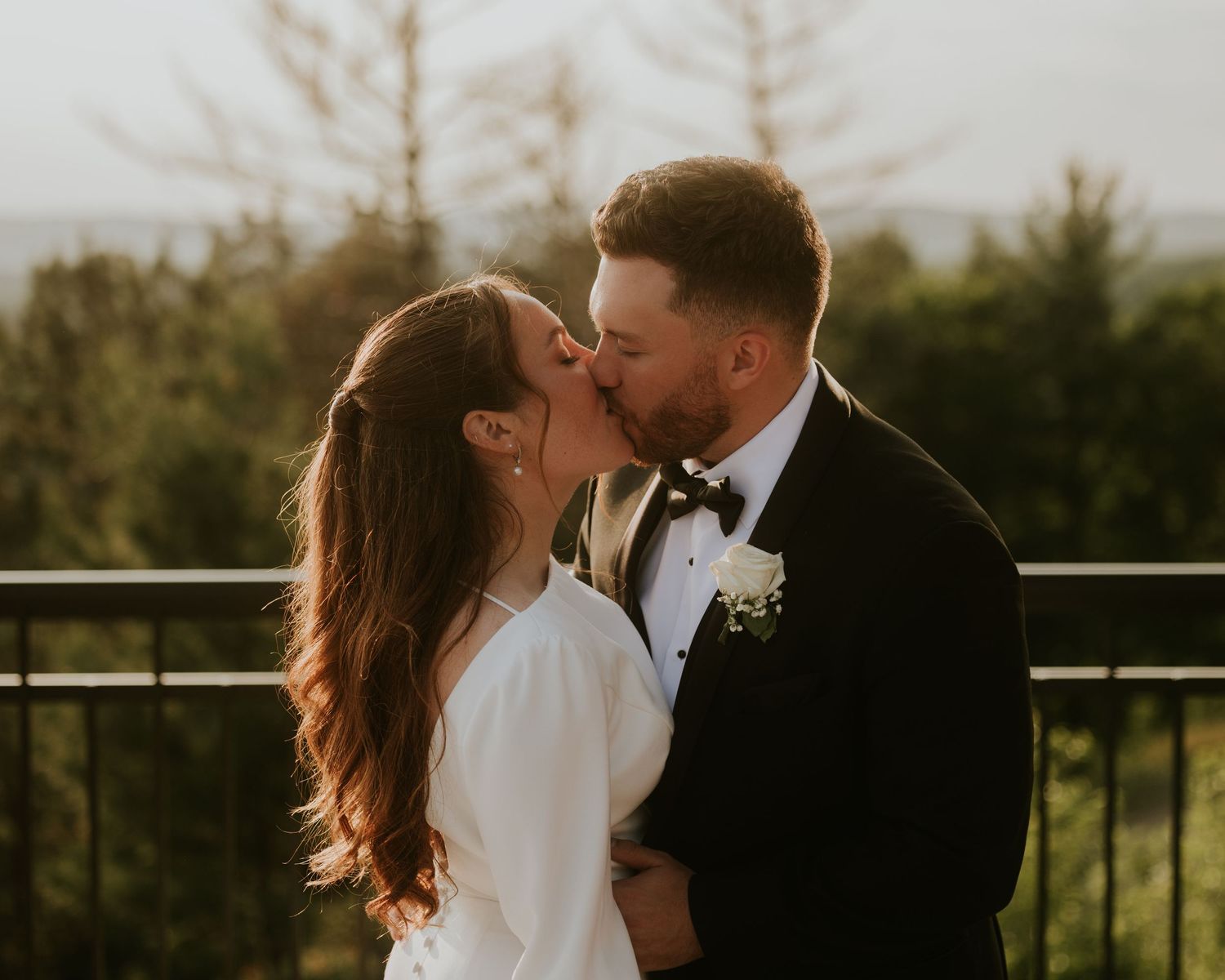 Romantic sunset wedding portraits captured on outdoor terrace with mountain views.
