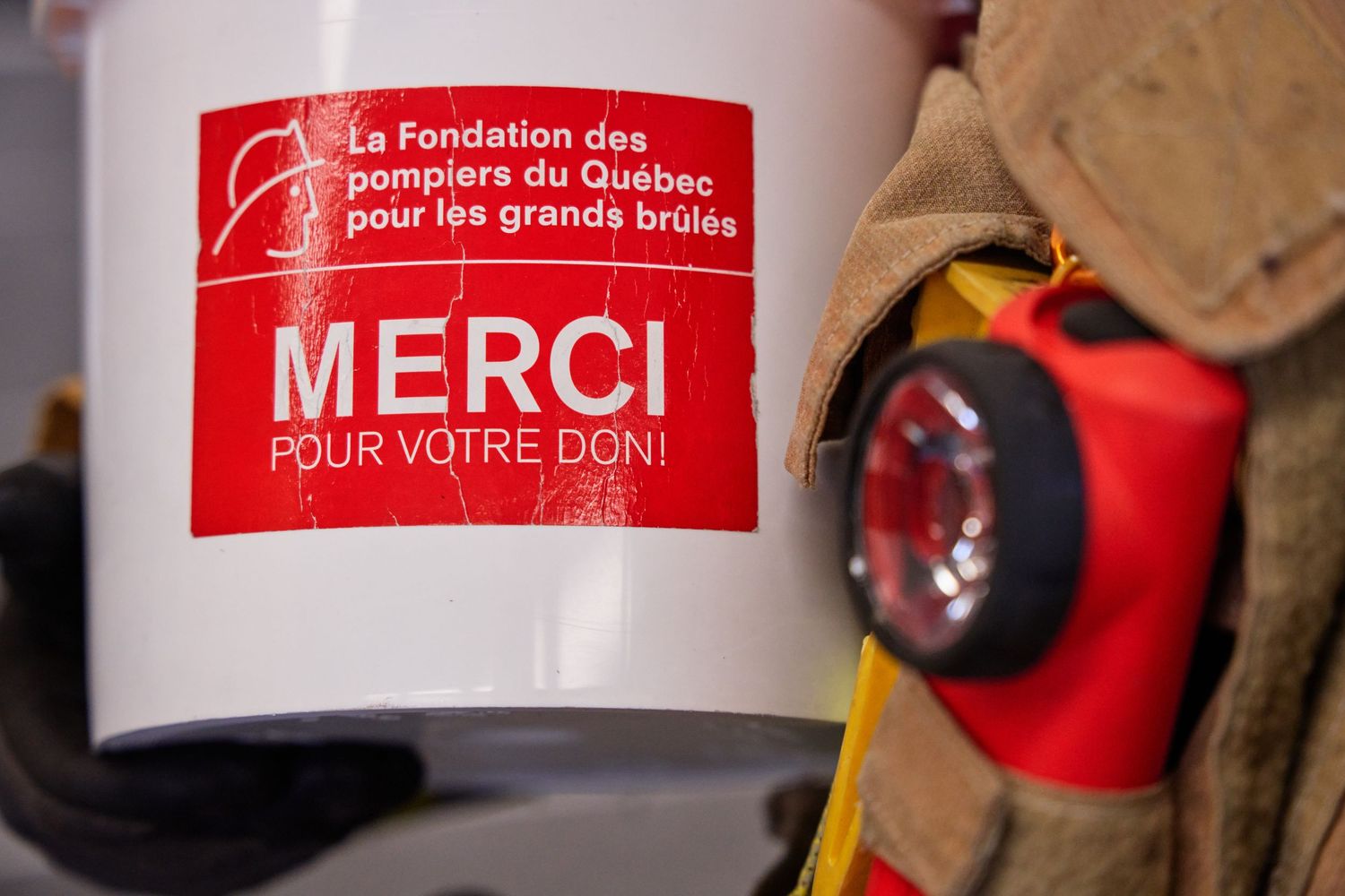 Red and white donation collection buckets with French text.