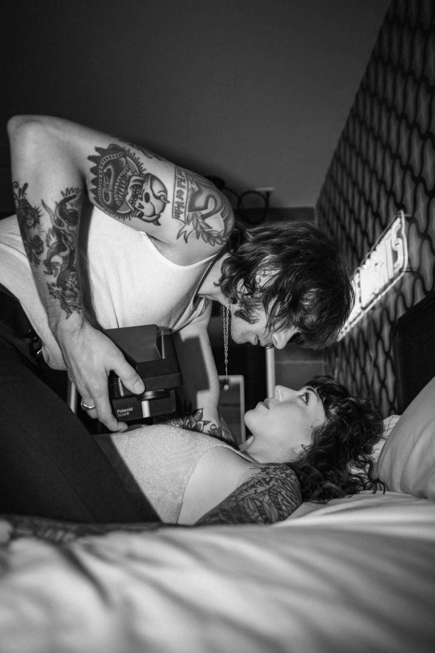 Black and white photo series of intimate couple moments against geometric wallpaper.