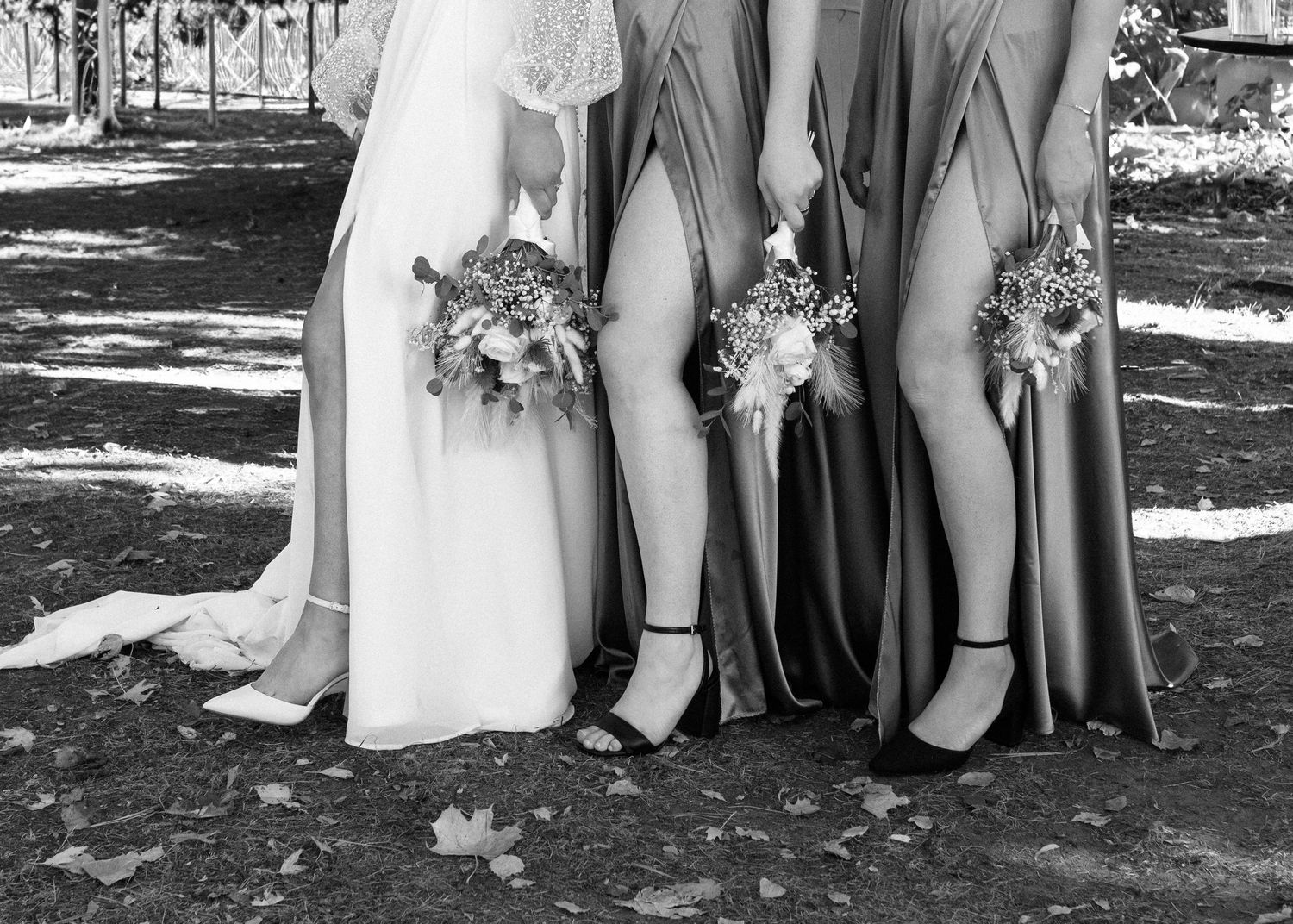 Wedding party poses in black and white showing shoes and dress hems.
