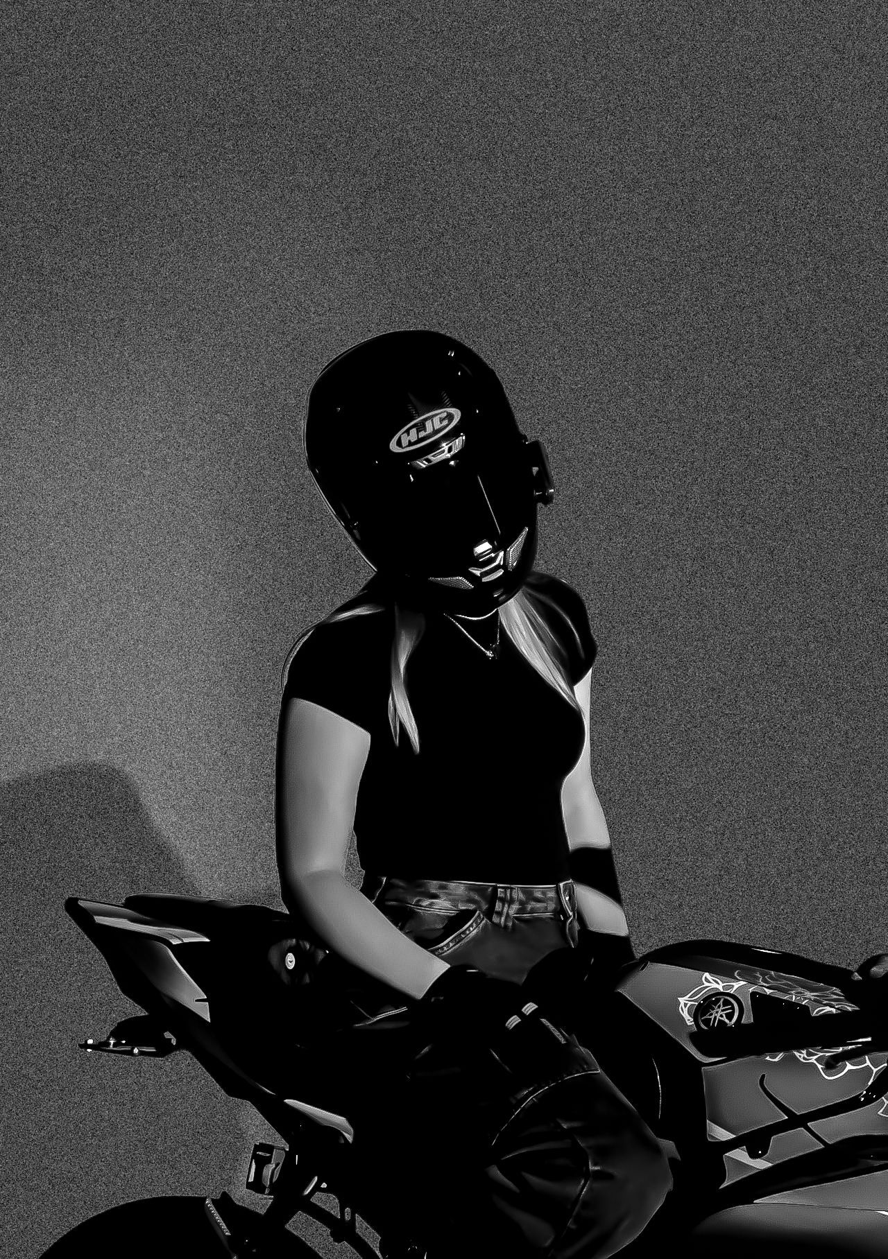 Silhouetted motorcycle rider in black gear against gray background.