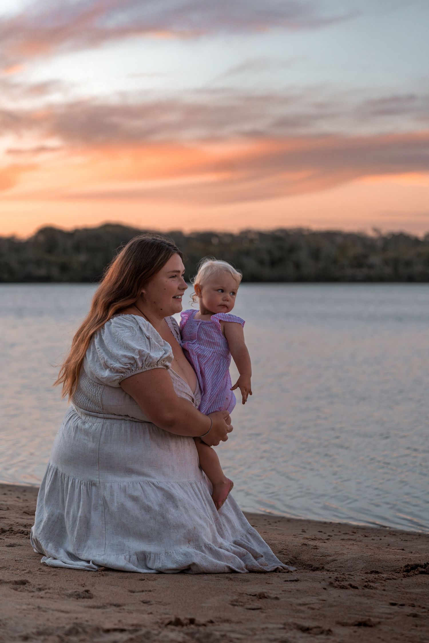 Peaceful lakeside moment between parent and child during golden hour.