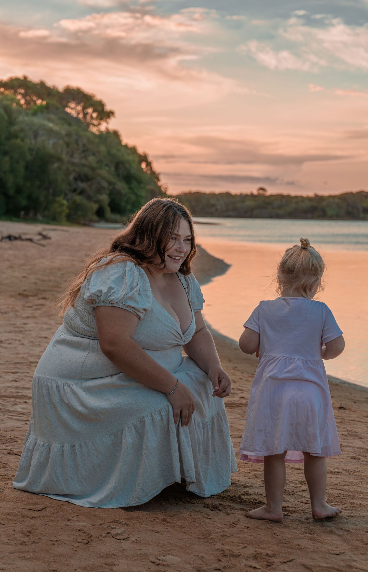 Sunset beach scene with parent and child sharing a joyful moment.