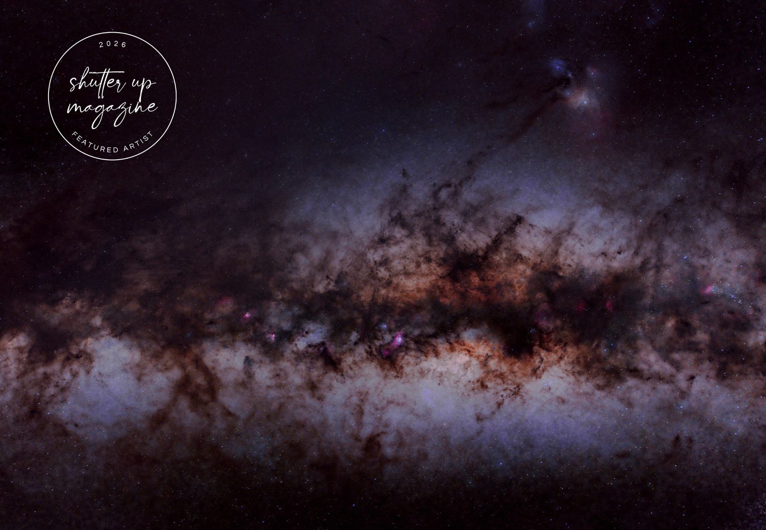 A dark panoramic view of the Milky Way galaxy stretching across the night sky with silhouetted trees below.