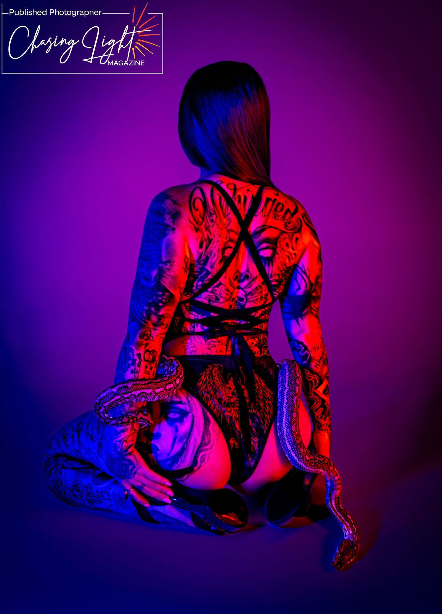 Artistic boudoir photo with dramatic red and blue lighting creating moody silhouette against purple background.