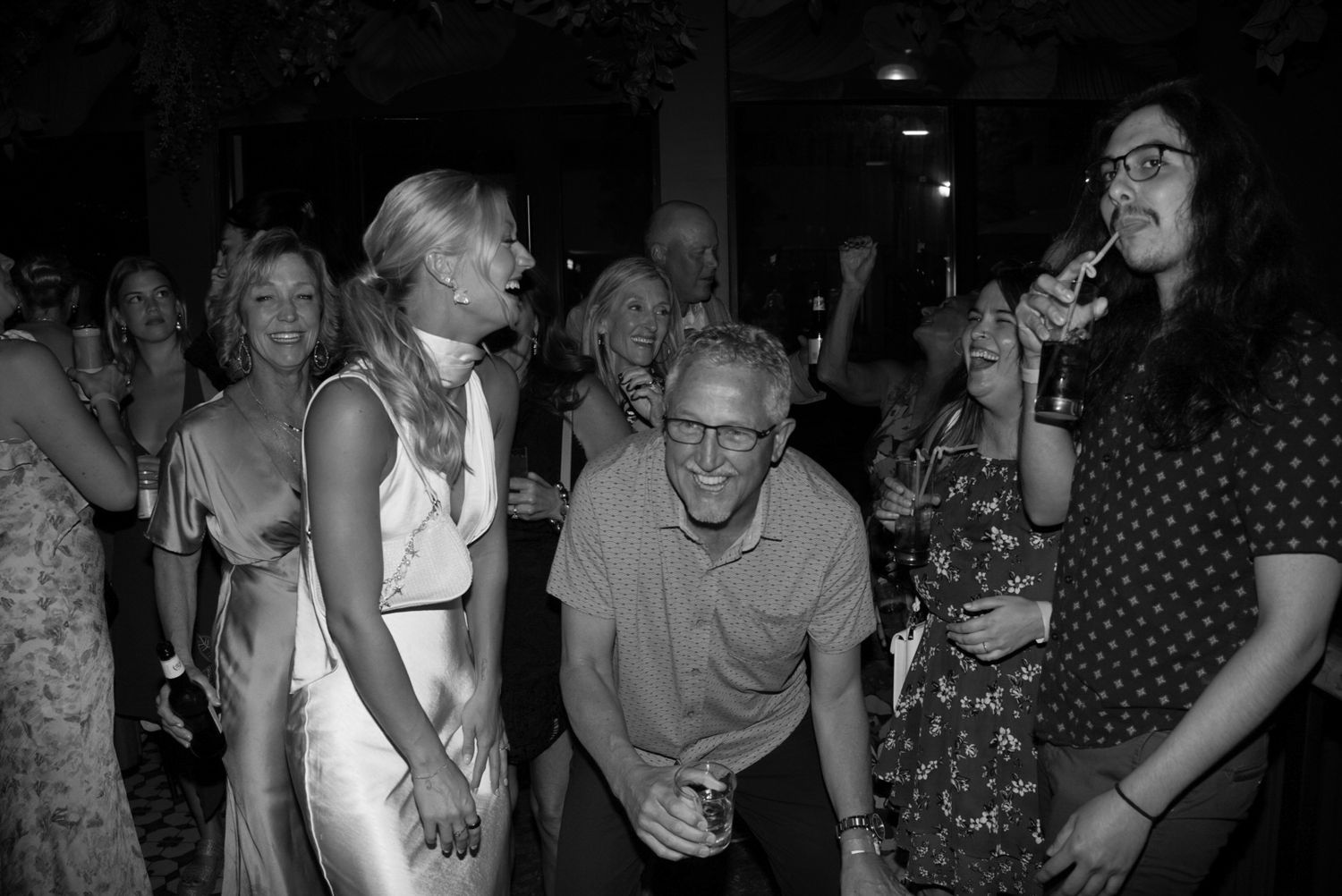A group of people socializing and drinking at a crowded bar.