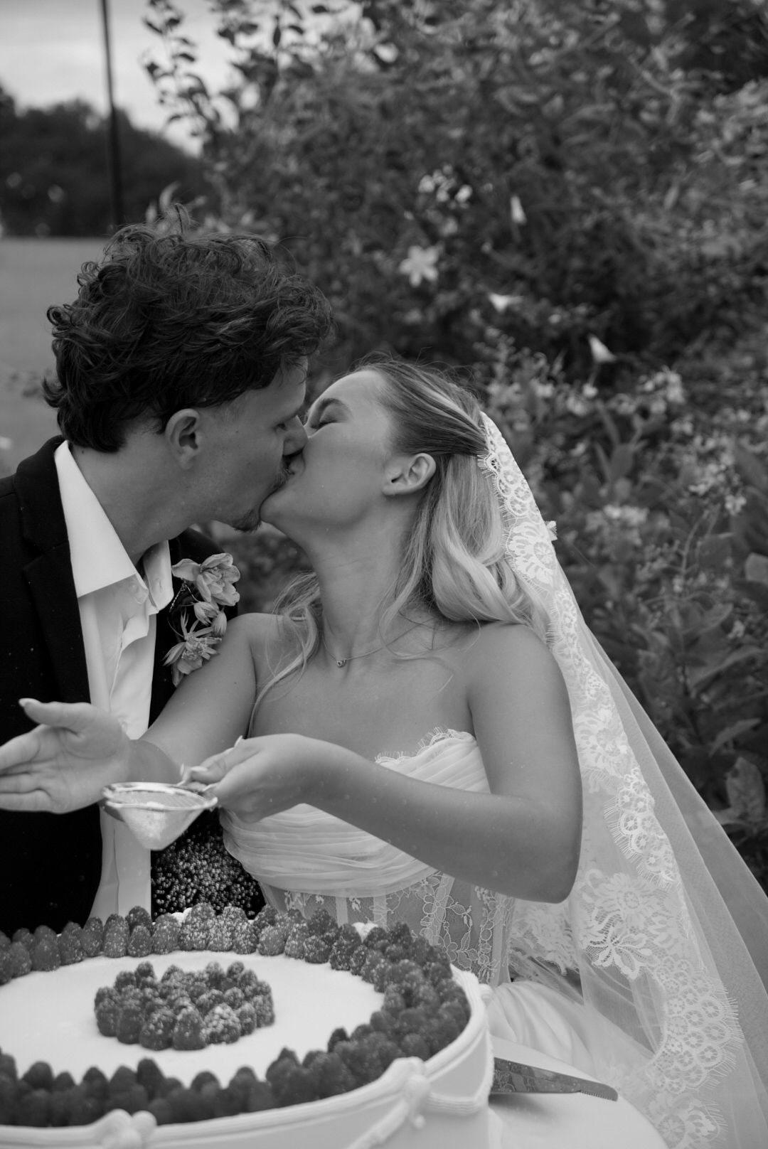Black and white wedding photo series showing couple sharing cake in romantic moment.