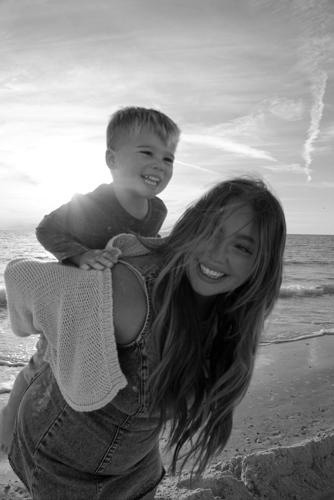 Candid black and white beach photos showing joyful moments at sunset.