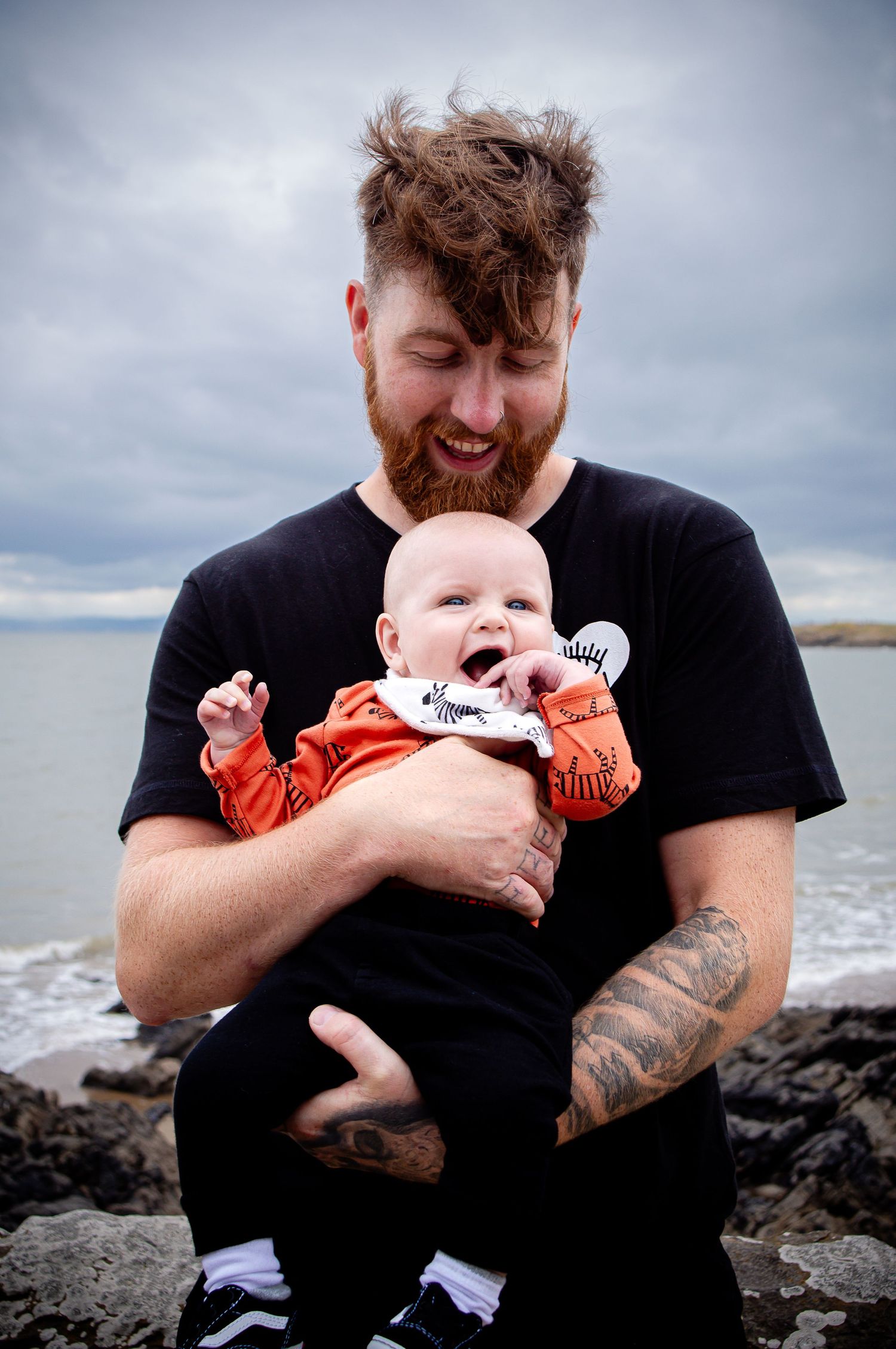 Father cuddling his baby during a family photoshoot at Barry Island