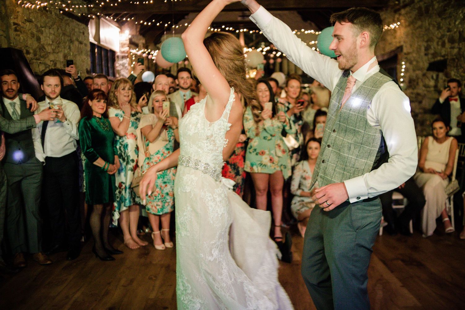 Bride twirling beneath the groom’s arm during their first dance