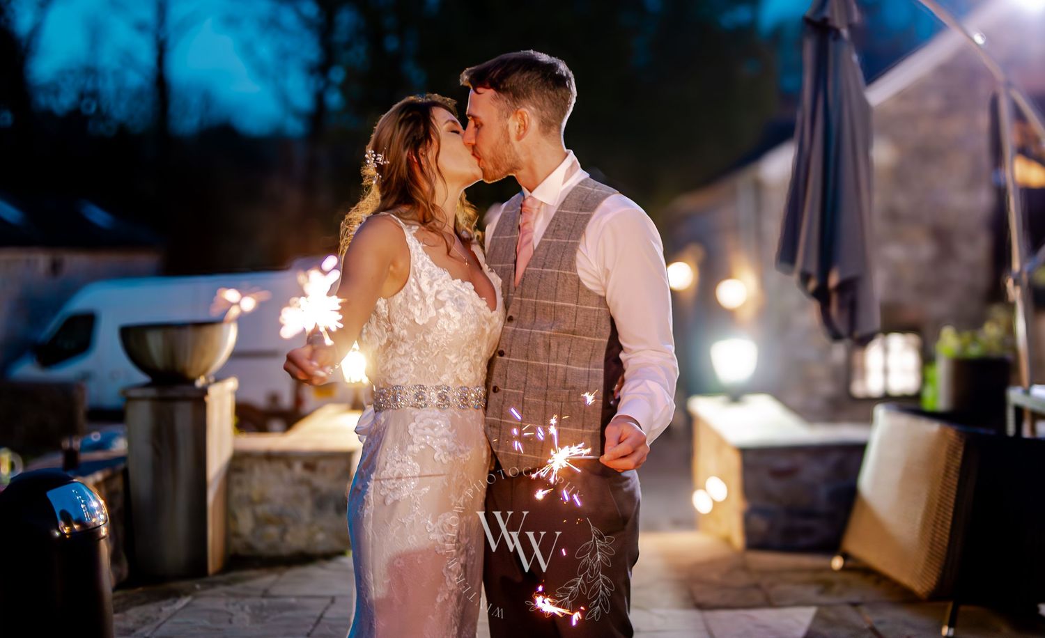 Bride and groom kissing with sparklers at their Pencoed House wedding